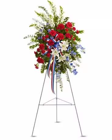 Standing floral spray with red, white, and blue flowers on an easel