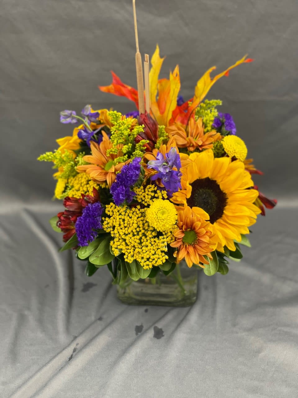 Hello Fall! - A bright, Colorful Fall Mix in a Cube Vase. Bright punchy colors accentuated with fall leaves. 