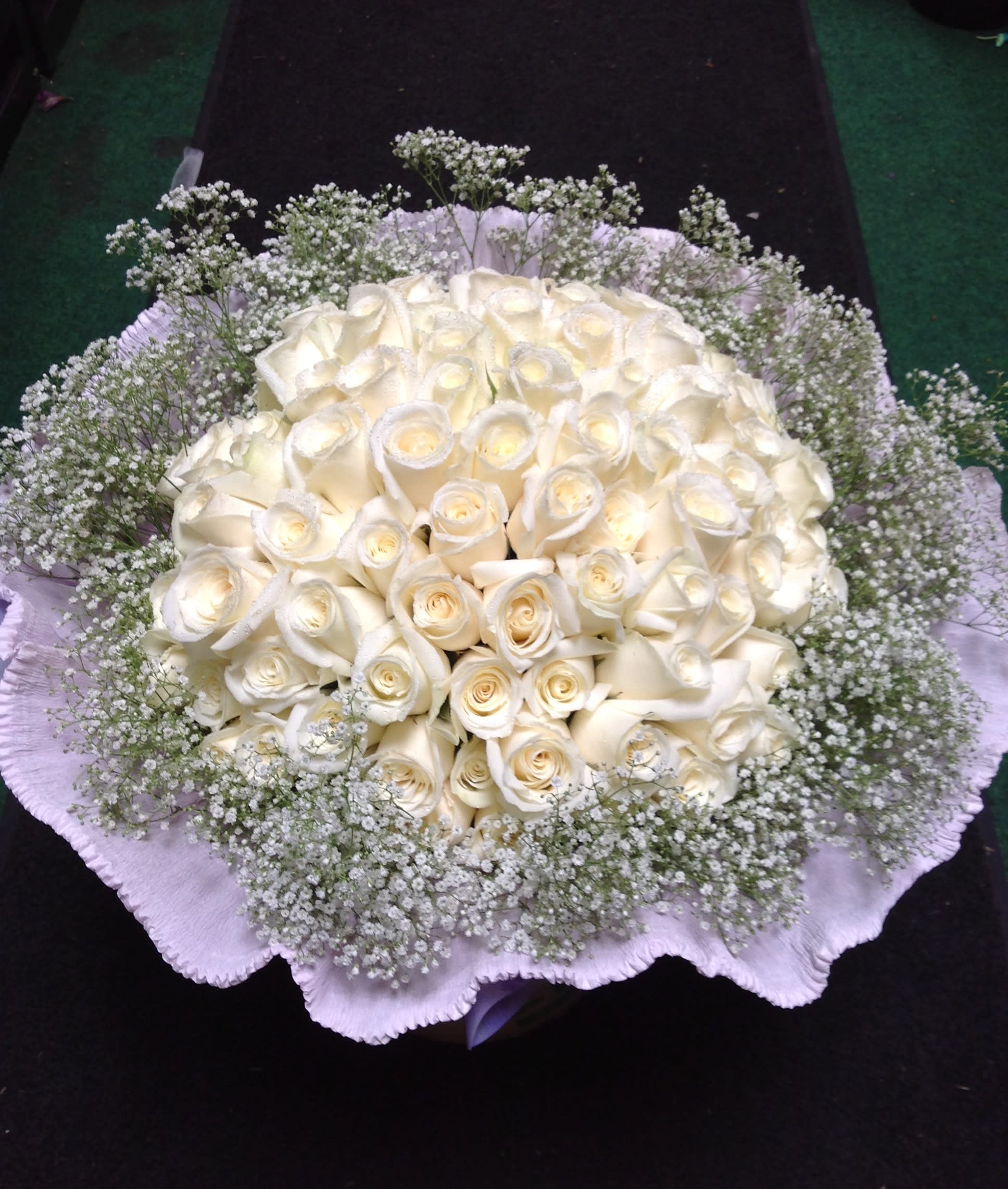 Round bouquet of white roses with baby's breath