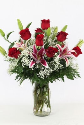Red roses and pink lilies arranged in a glass vase