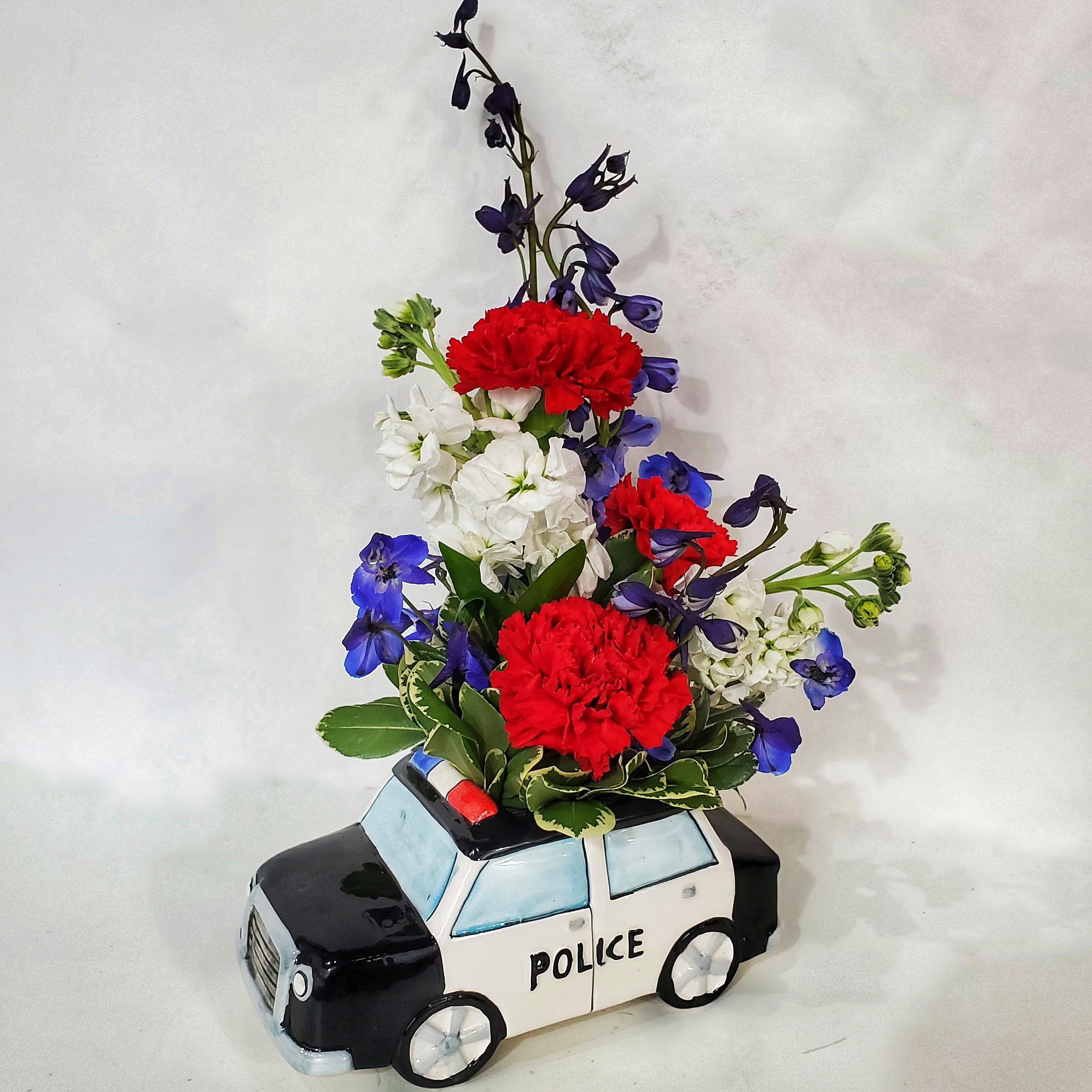 Flowers arranged in a police car-shaped container
