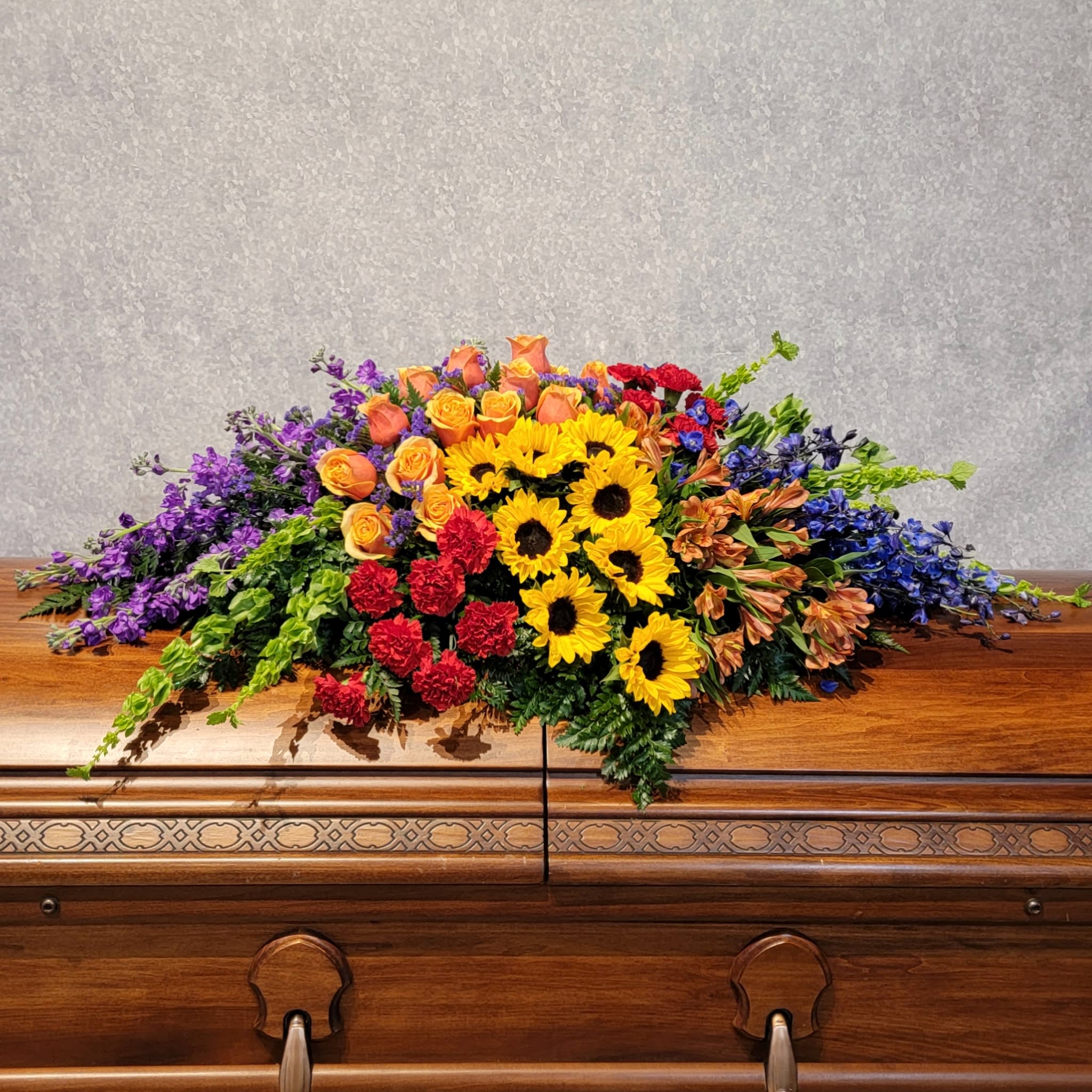 Colorful floral spray on a wooden casket