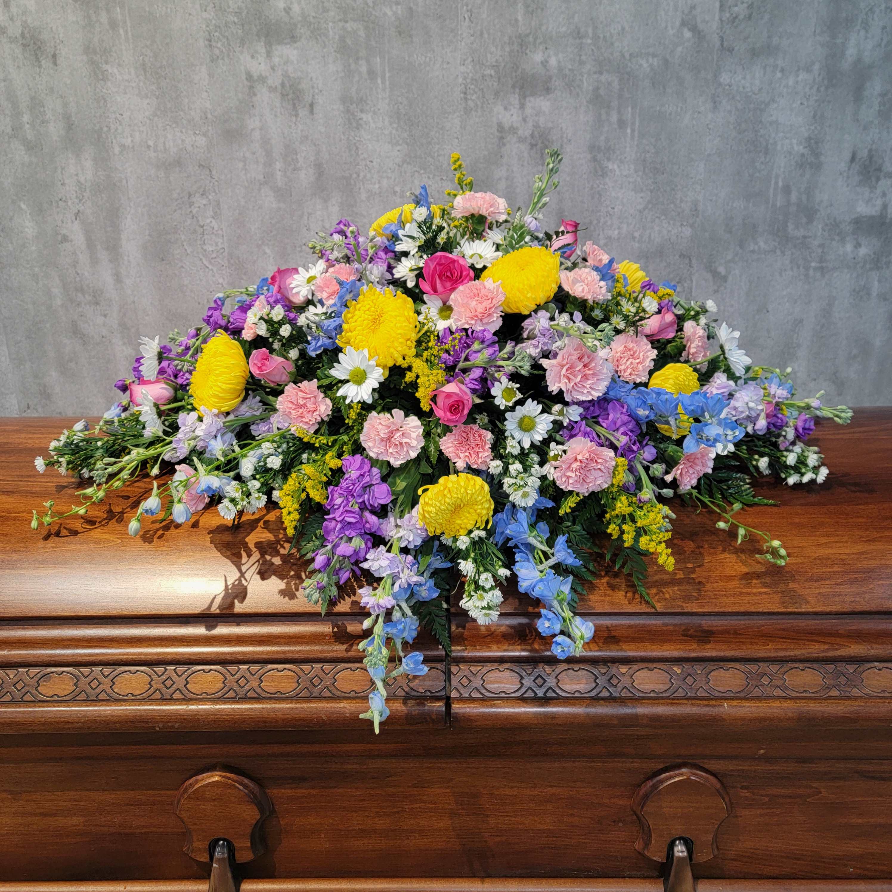 Colorful floral spray on a wooden casket