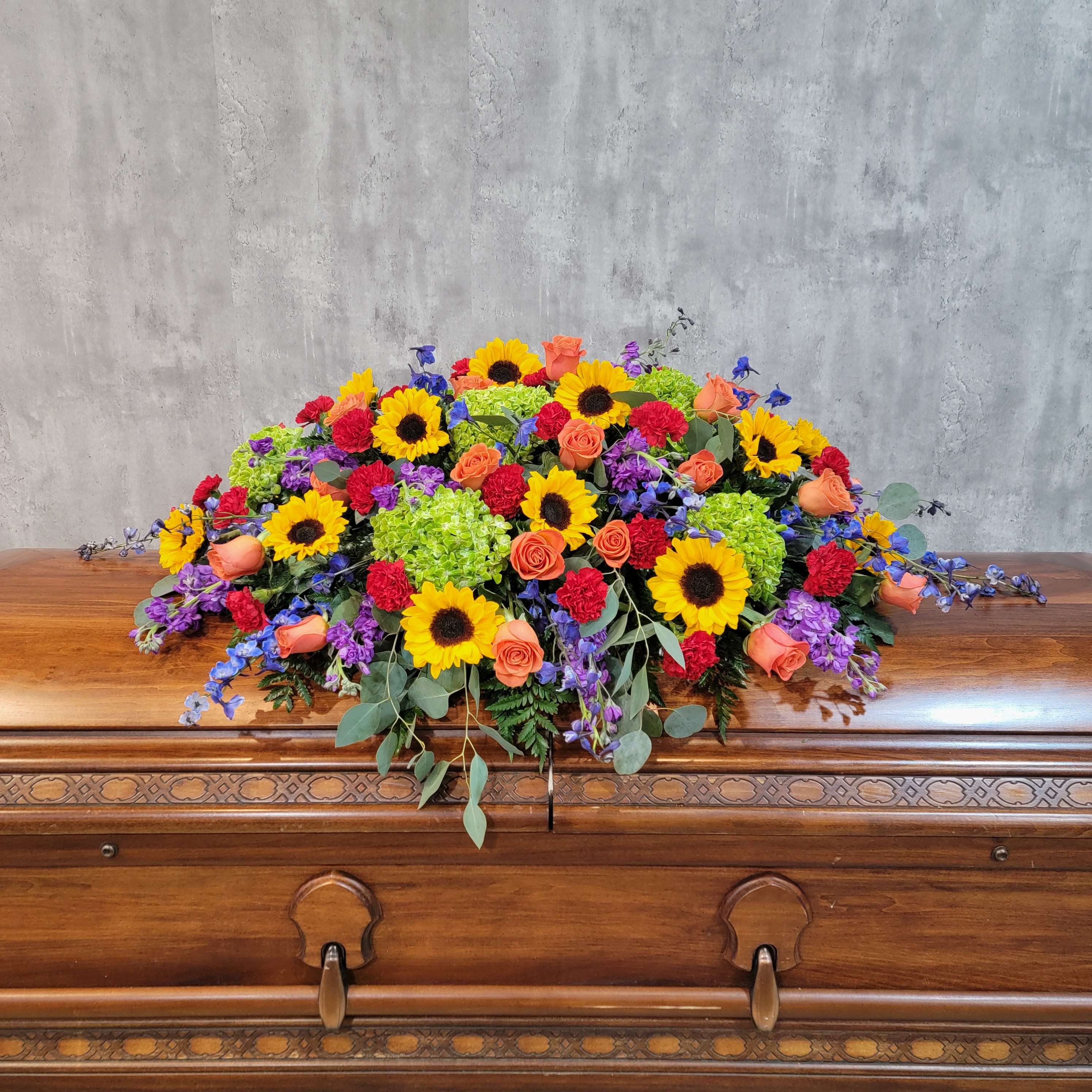 Colorful floral spray on a wooden casket