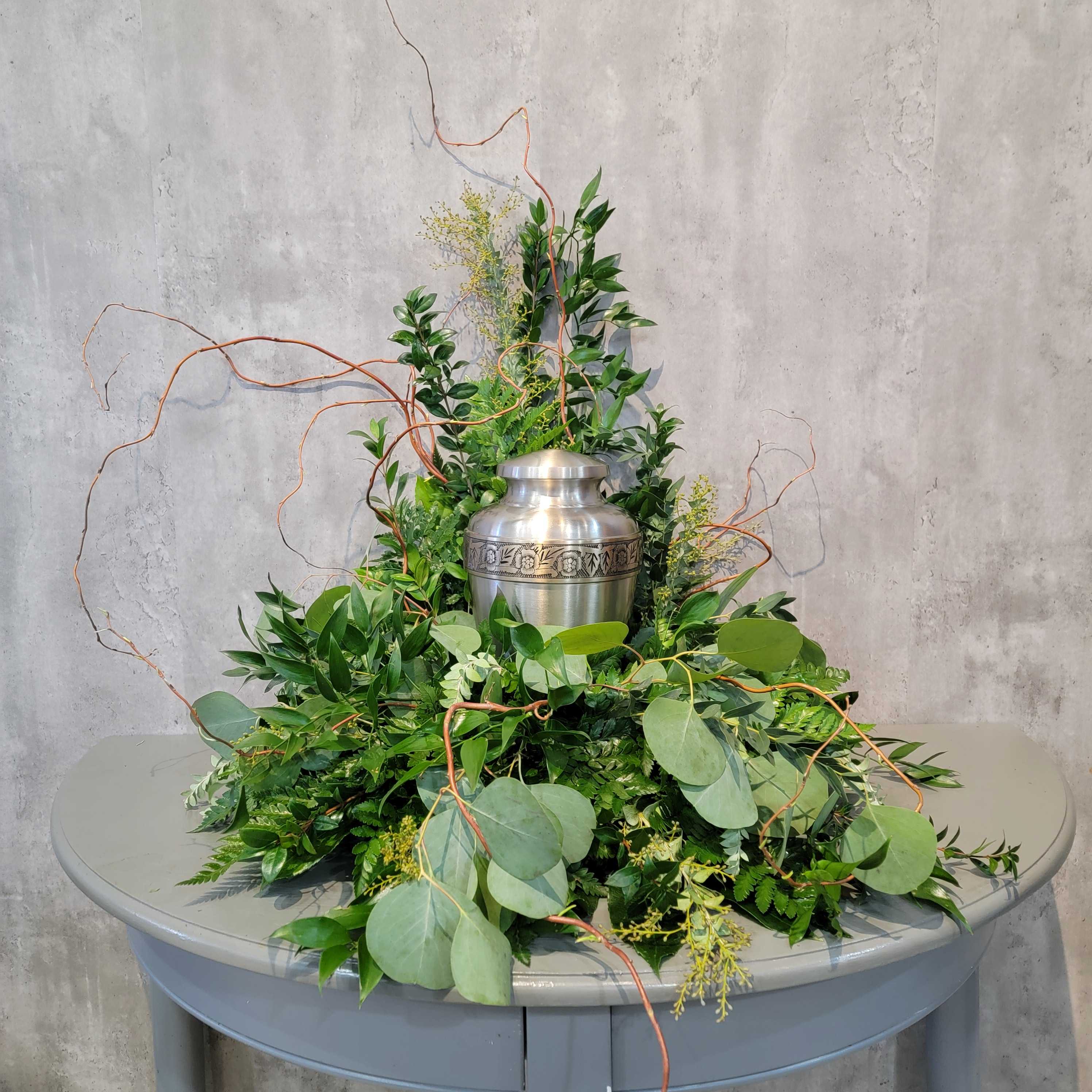 Green foliage arrangement with a silver urn centerpiece