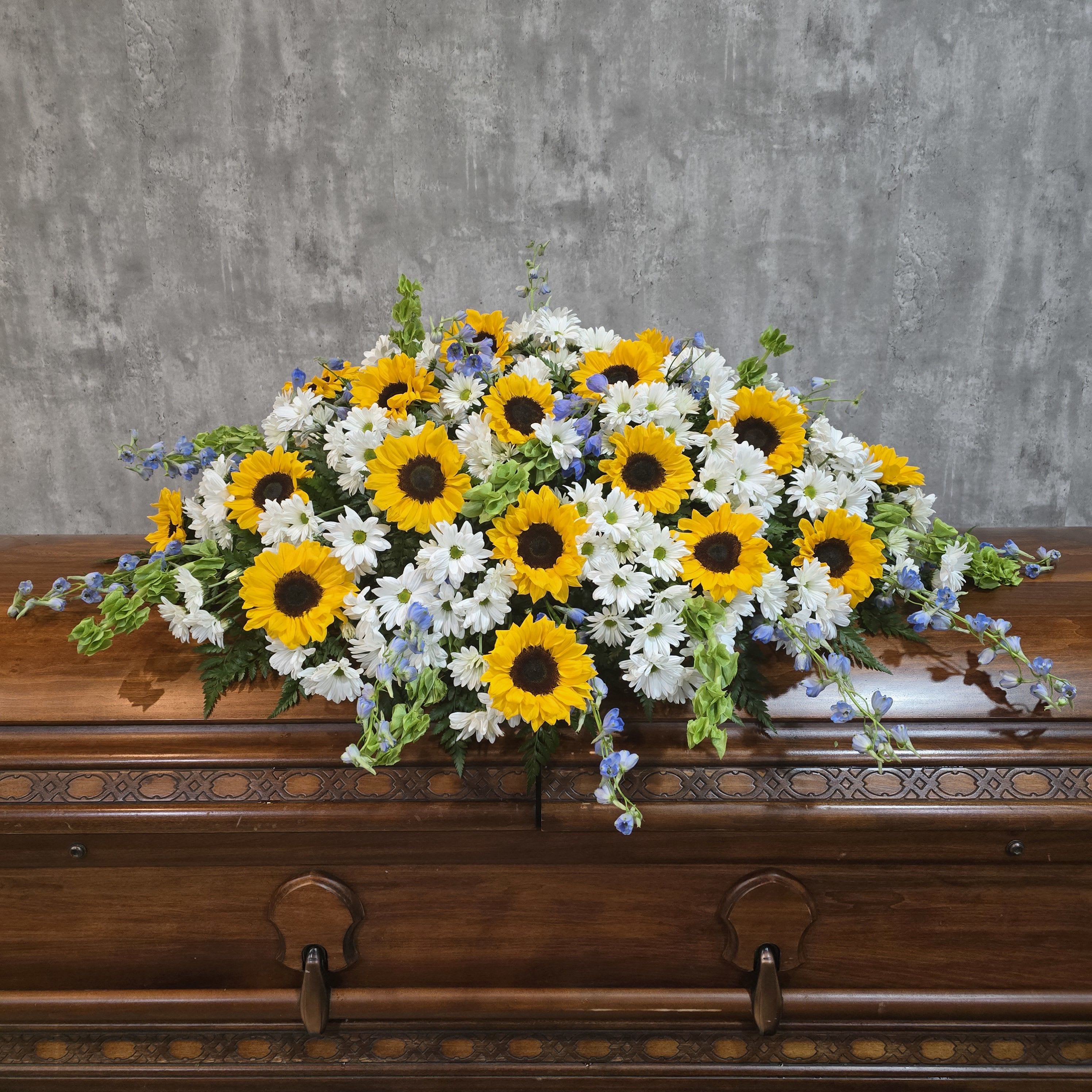 Sunflower and white daisy casket spray with blue accents
