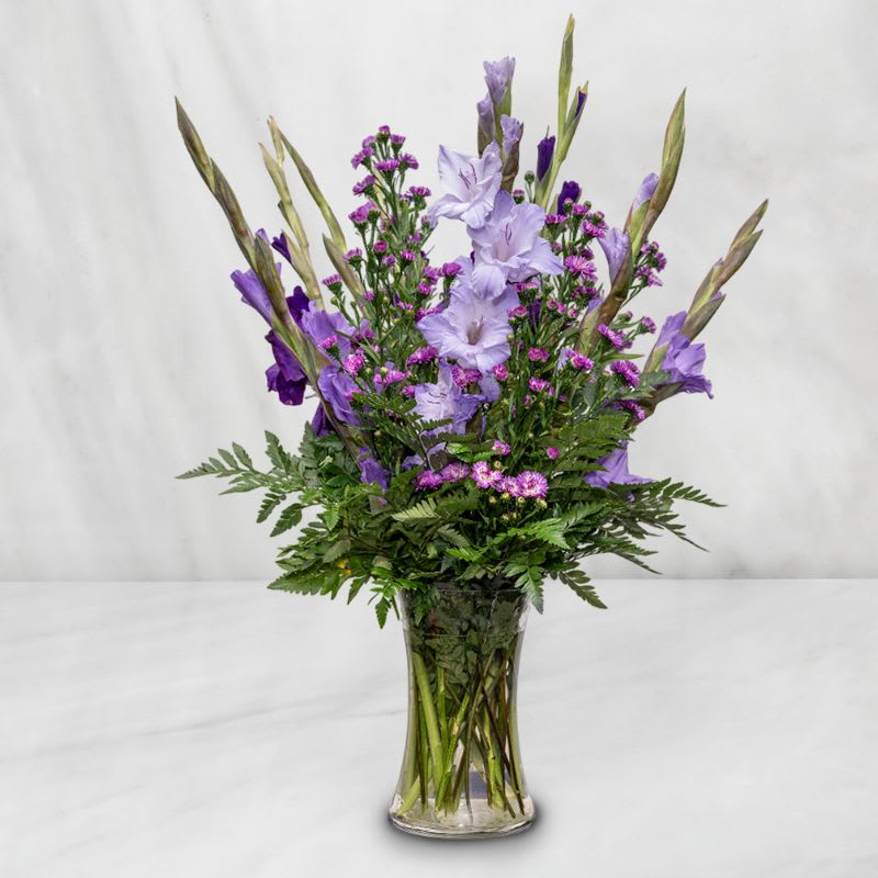 Purple flowers arranged in a clear glass vase