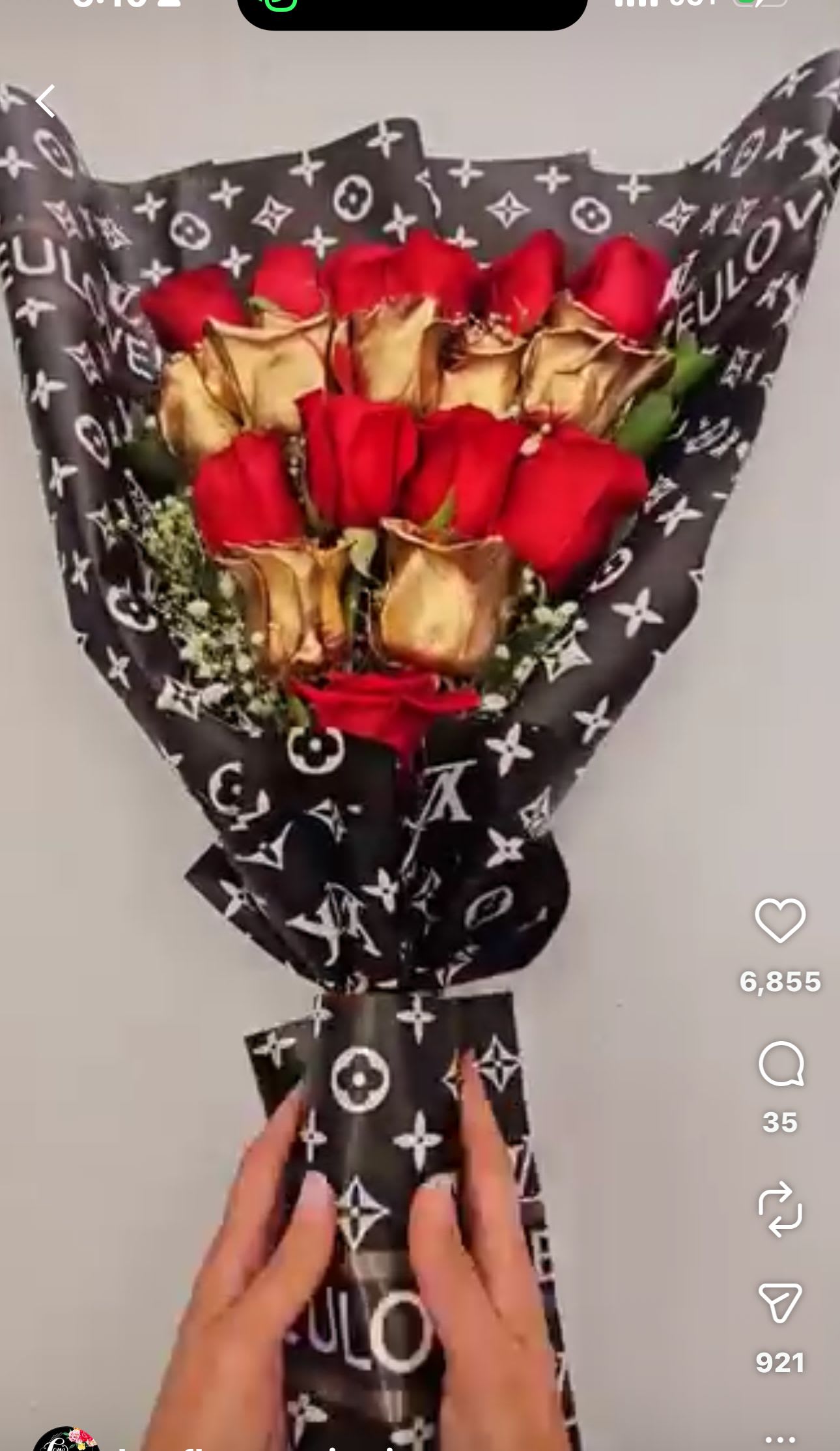 Bouquet of red roses wrapped in black patterned paper with gold accents
