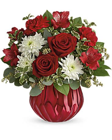 Red roses and white daisies in a red glass vase