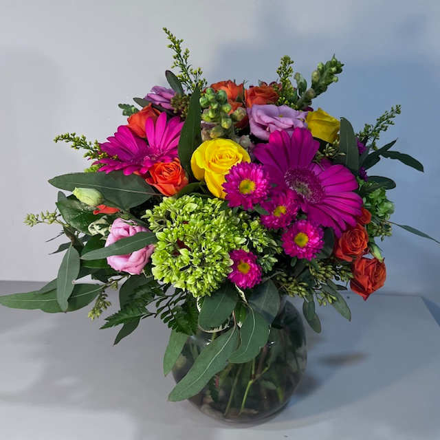 Mixed bouquet of bright flowers in a glass vase