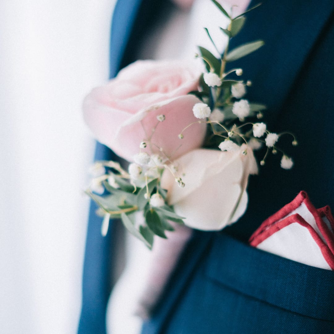 Pink roses with white filler flowers on a dark suit jacket