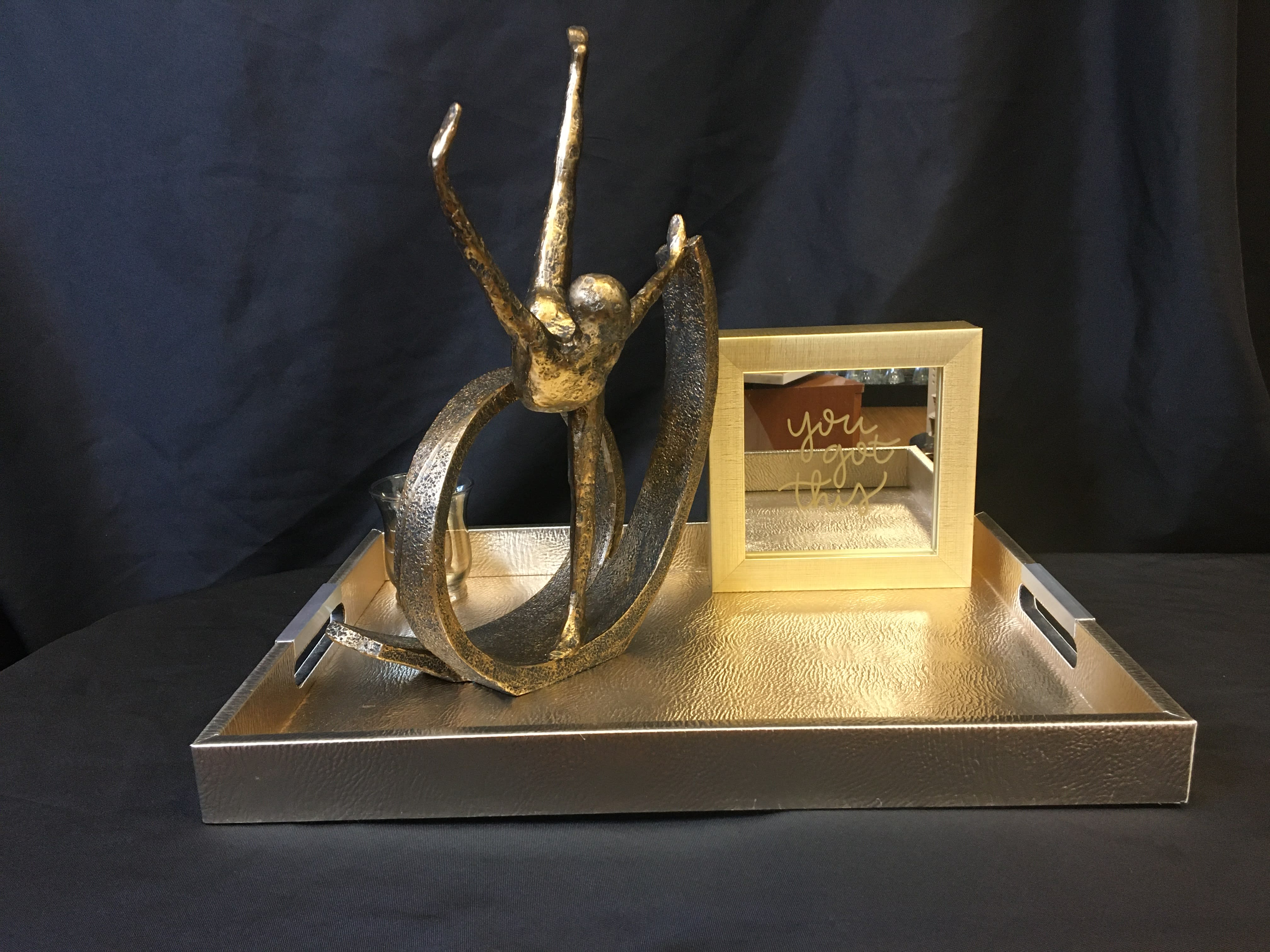 Gold decorative tray with abstract sculpture and framed mirror sign
