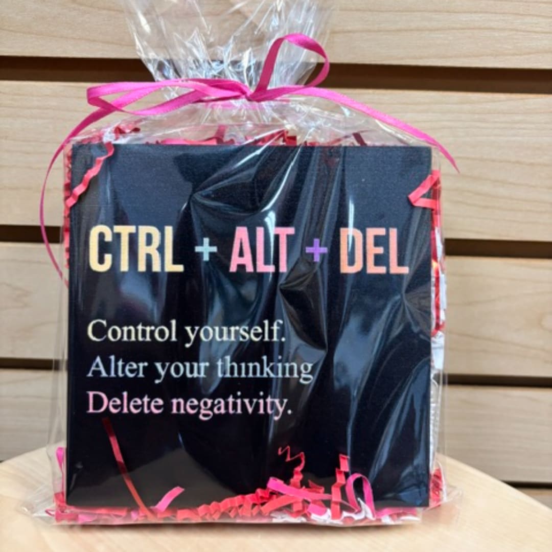 Gift bag with a black card reading "CTRL + ALT + DEL" and pink ribbon