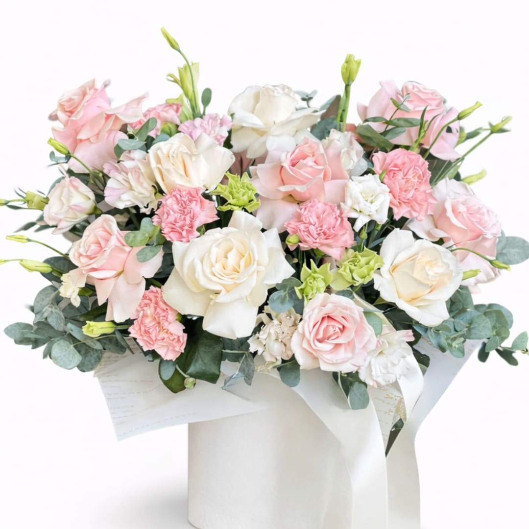 Bouquet of pink and white roses with carnations in white wrap