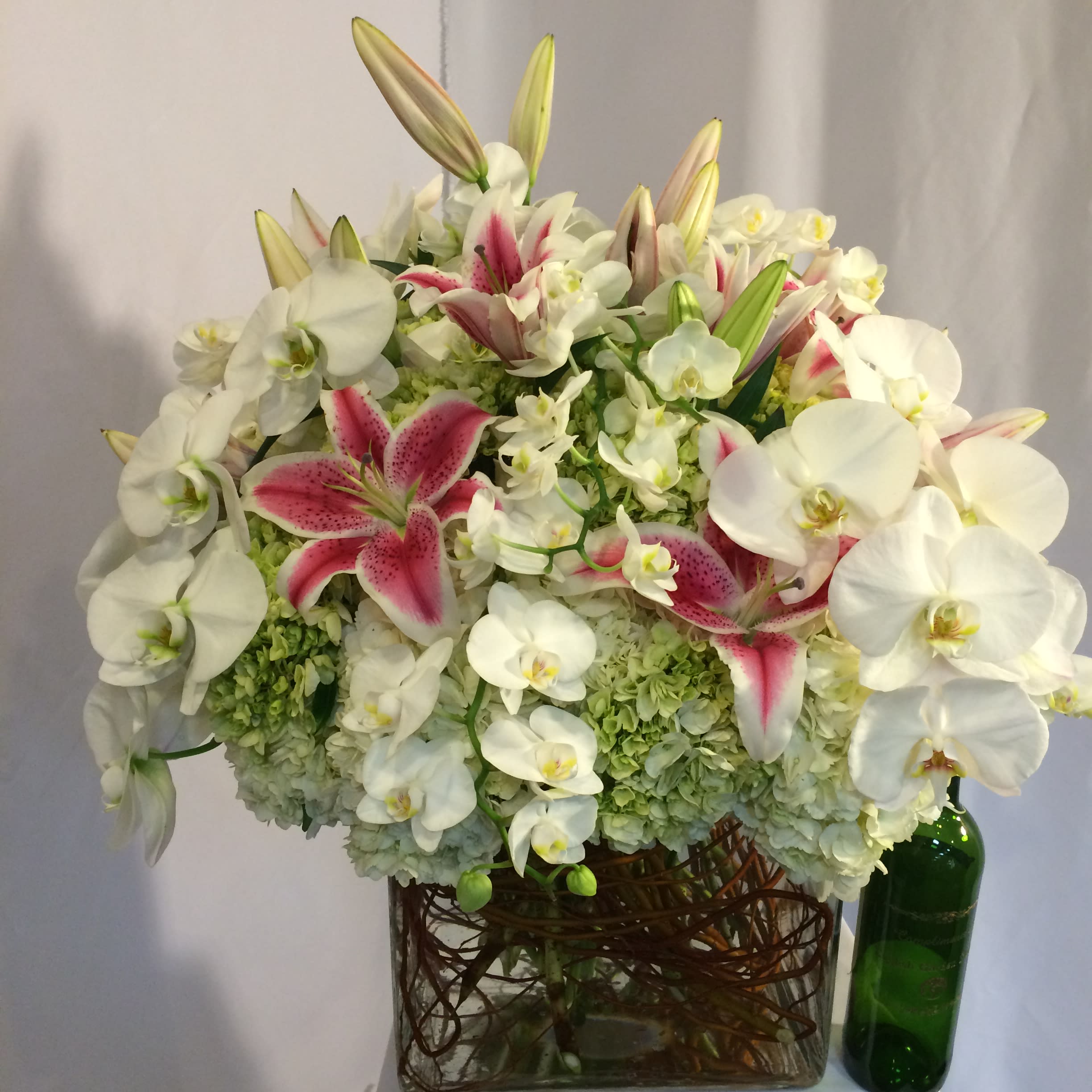 White orchids and pink lilies arranged in a glass vase