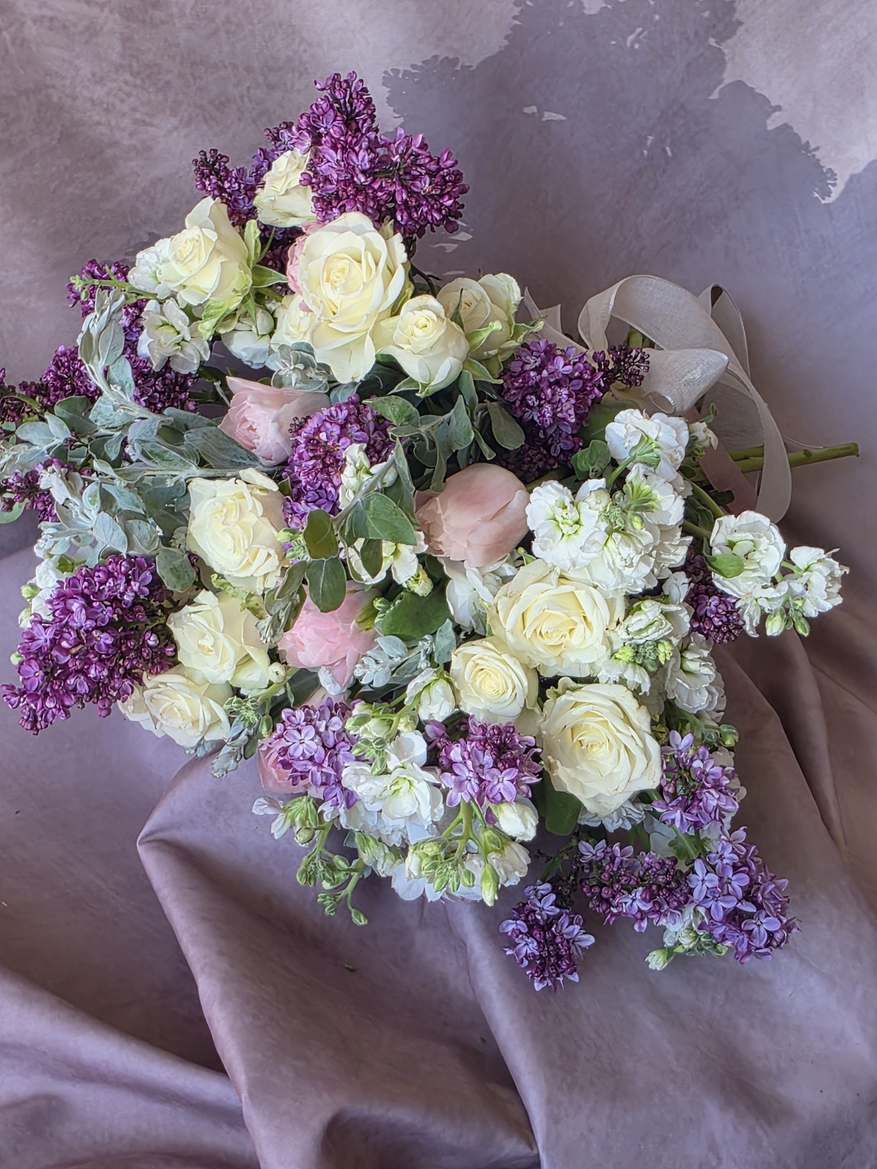Elizabeth  Bennet - A delicate and romantic bouquet featuring soft lilac blooms, elegant white roses, and graceful pink tulips. This harmonious blend creates a dreamy pastel palette that feels fresh, feminine, and timeless. Perfect for expressing love, gratitude, or gentle elegance, it brings a sense of calm beauty and light sophistication to any moment.