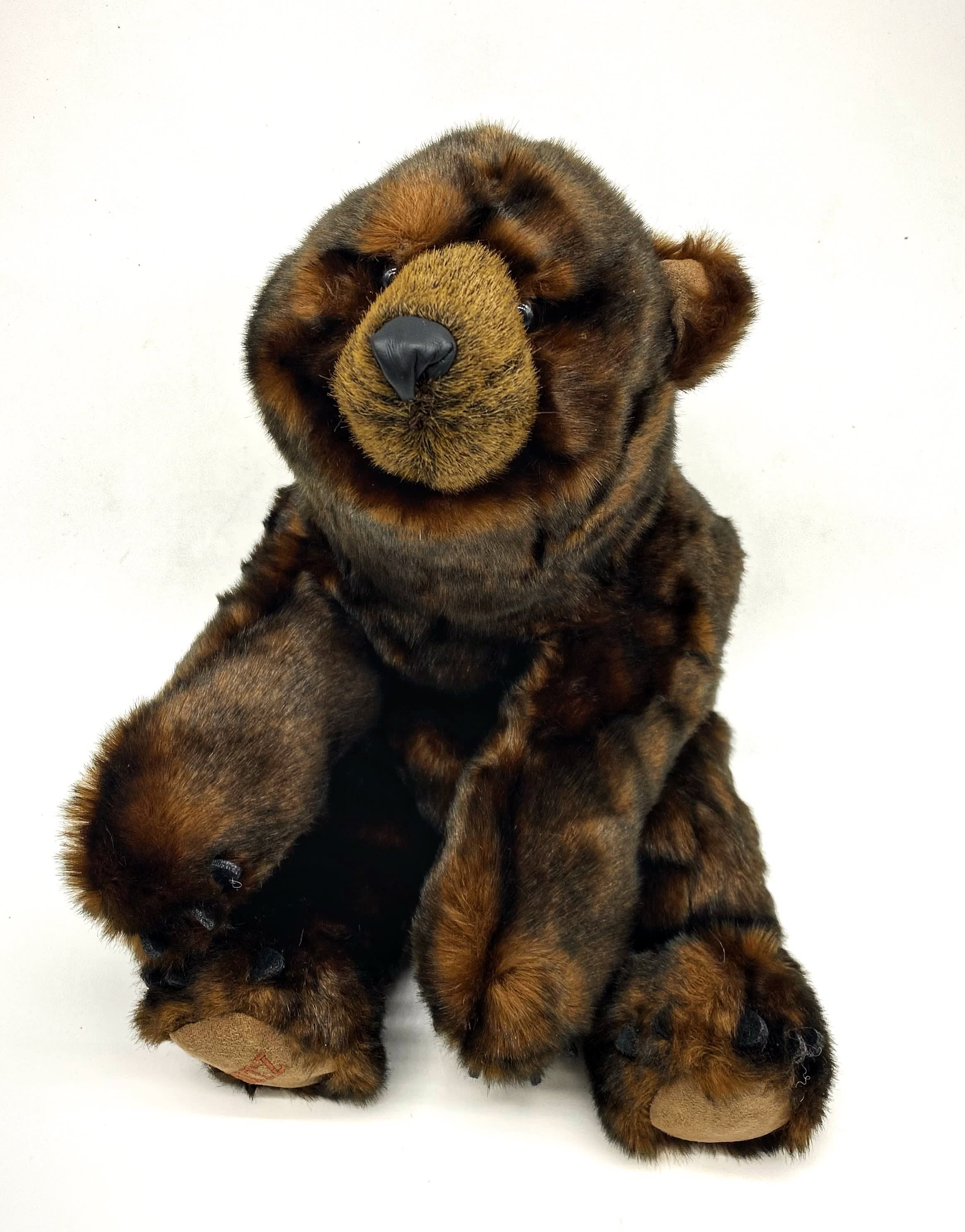 Brown plush teddy bear sitting on a white background