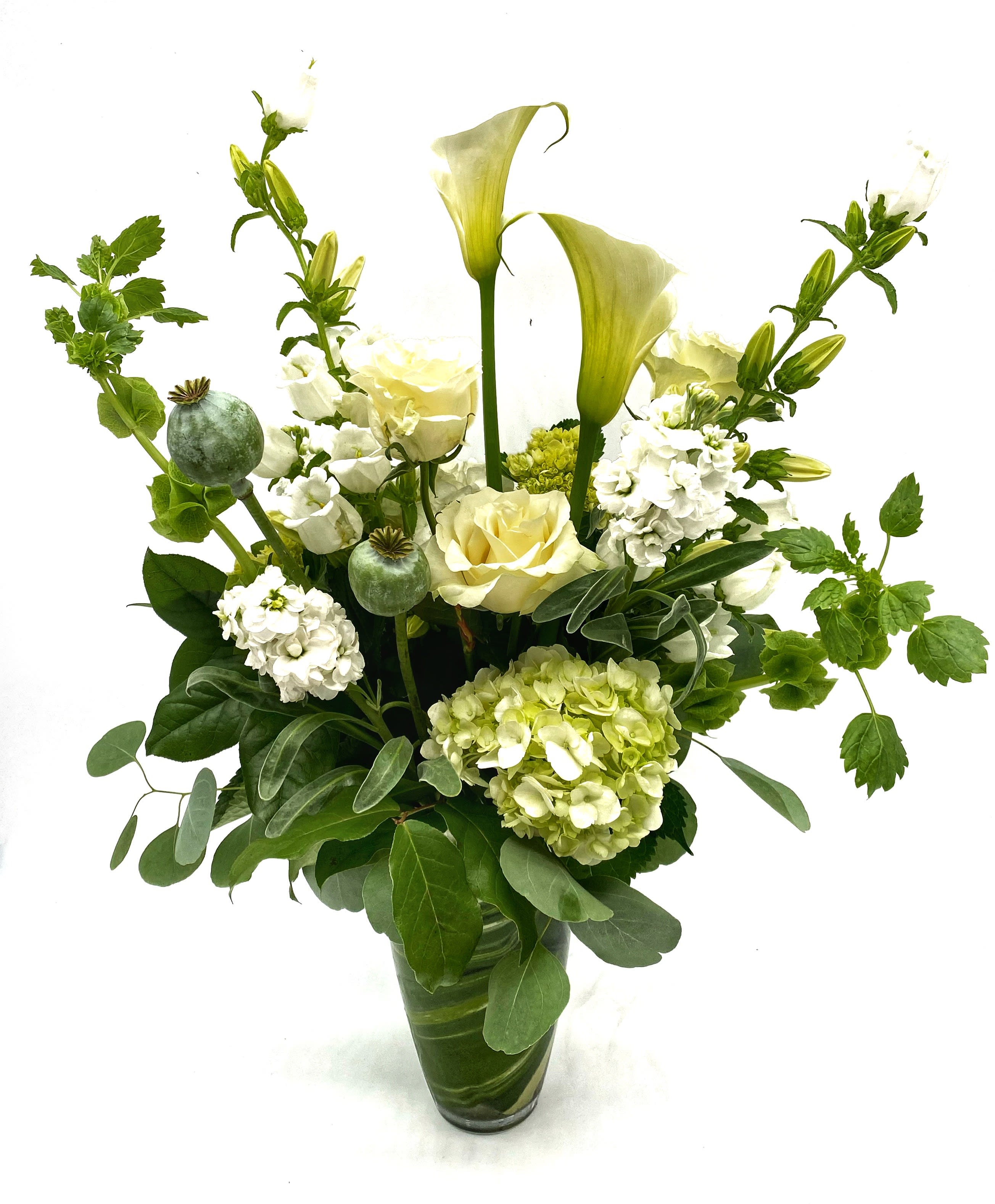 White and pale green floral arrangement in a glass vase