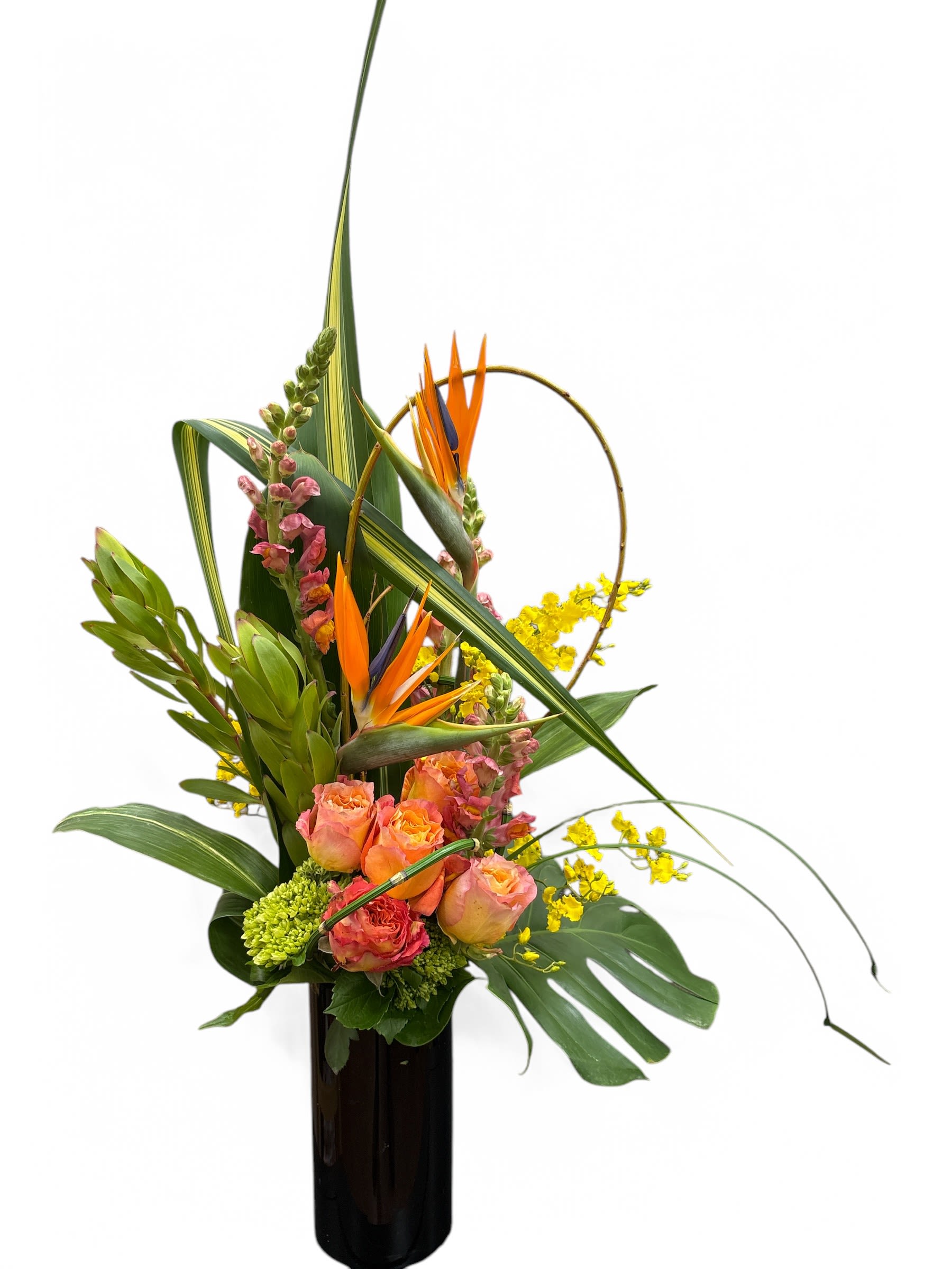 Tropical flower arrangement in a tall black vase with orange blooms and yellow accents
