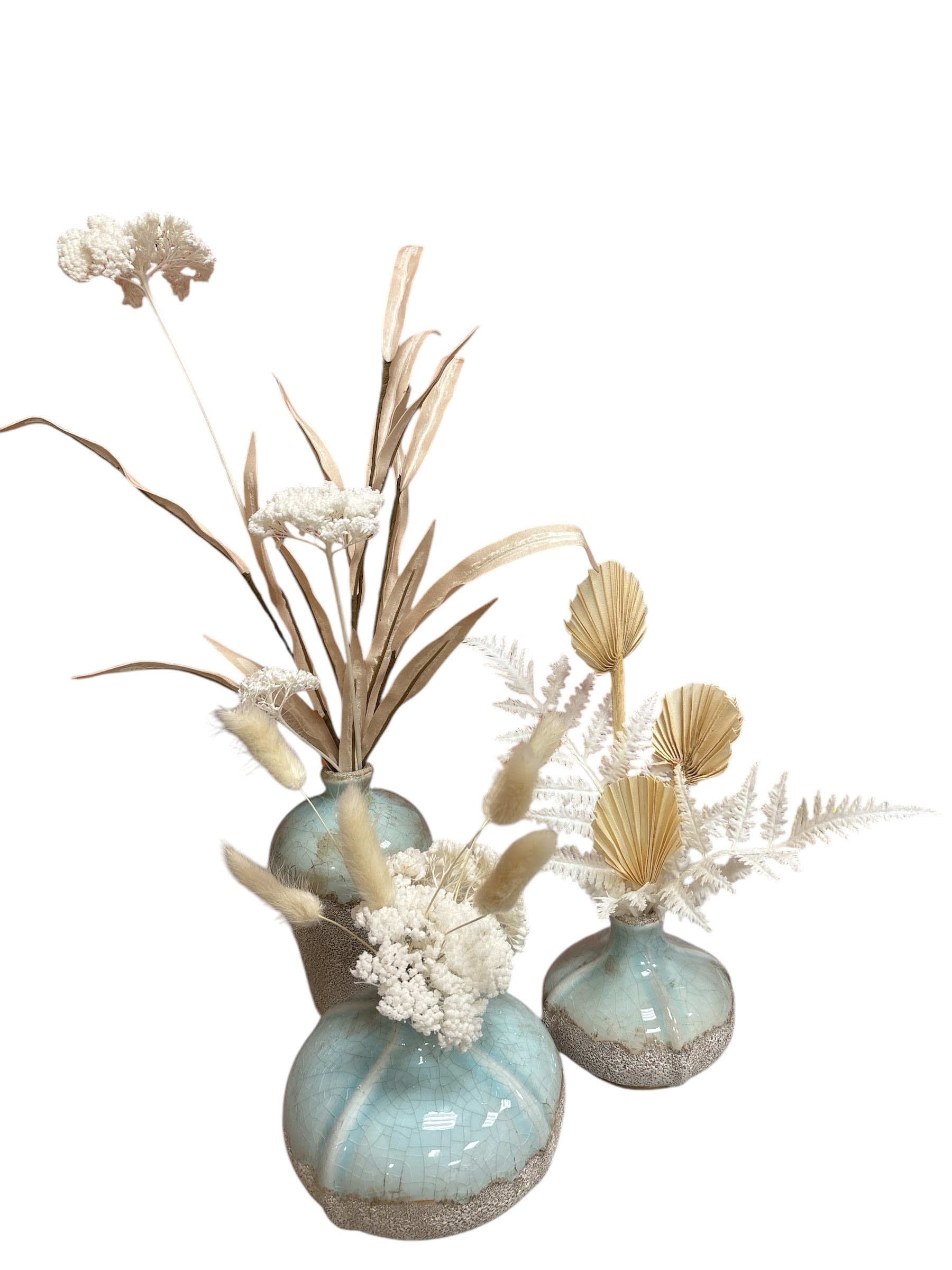 Three dried floral arrangements in blue ceramic vases