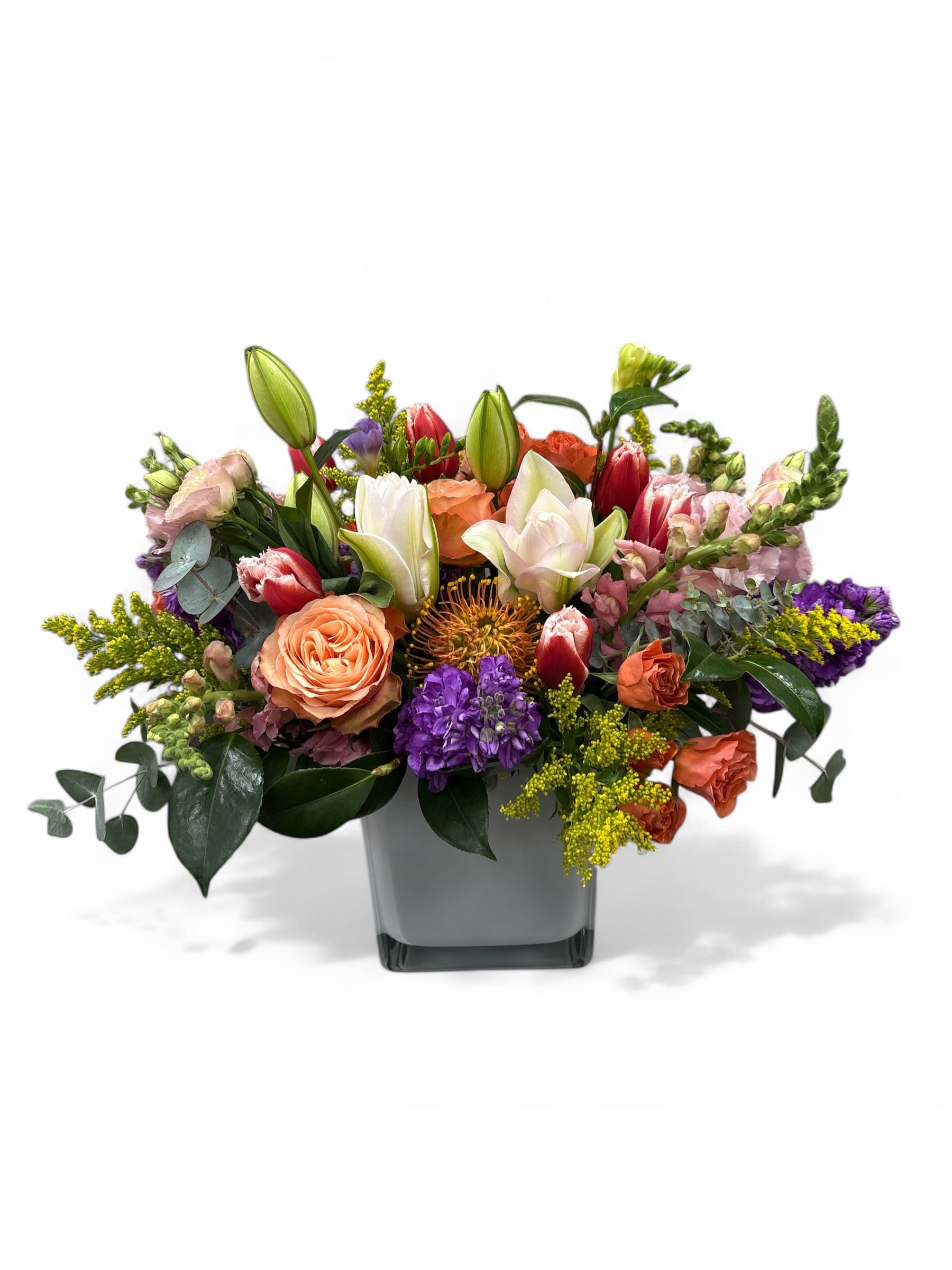 Floral Menagerie  - Bright colors of spring garden blooms arranged in a large and heavy white glass cube 