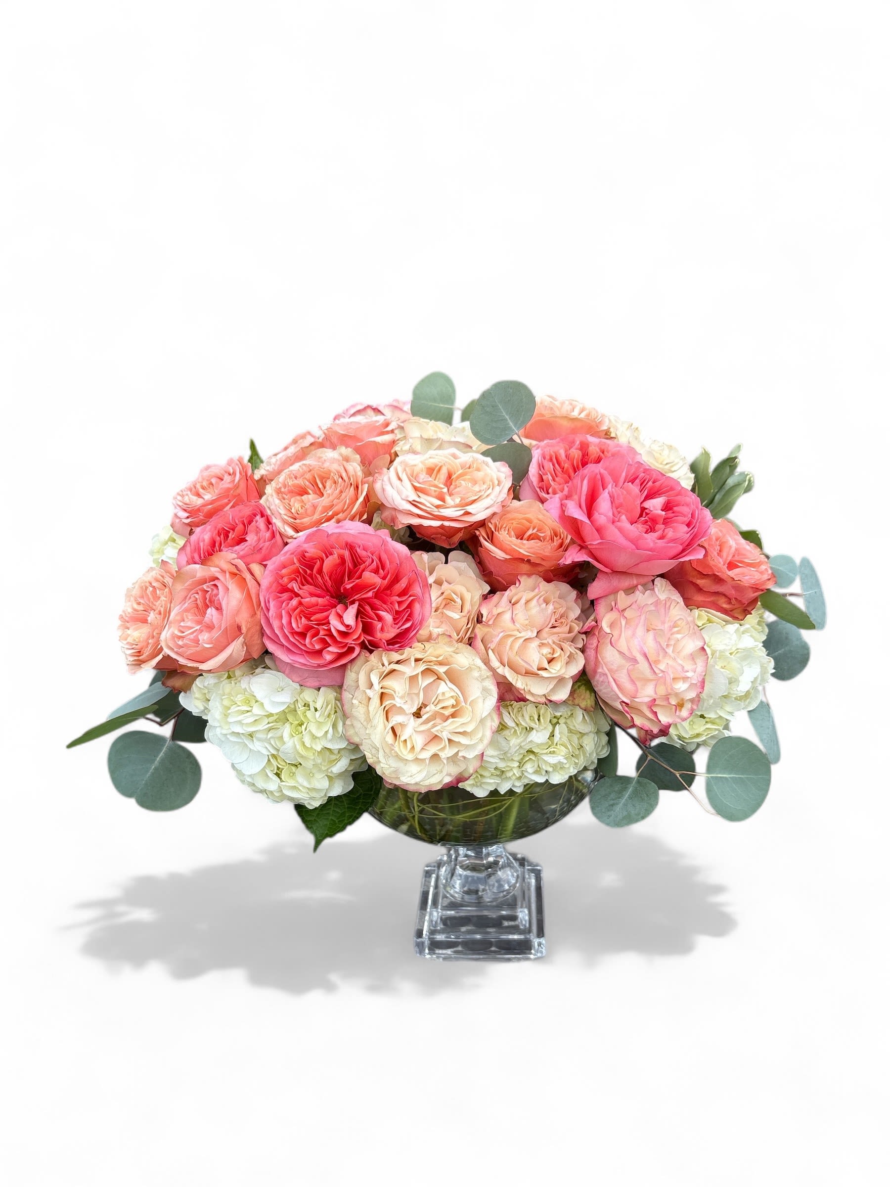 Pink and peach roses arranged in a clear glass vase