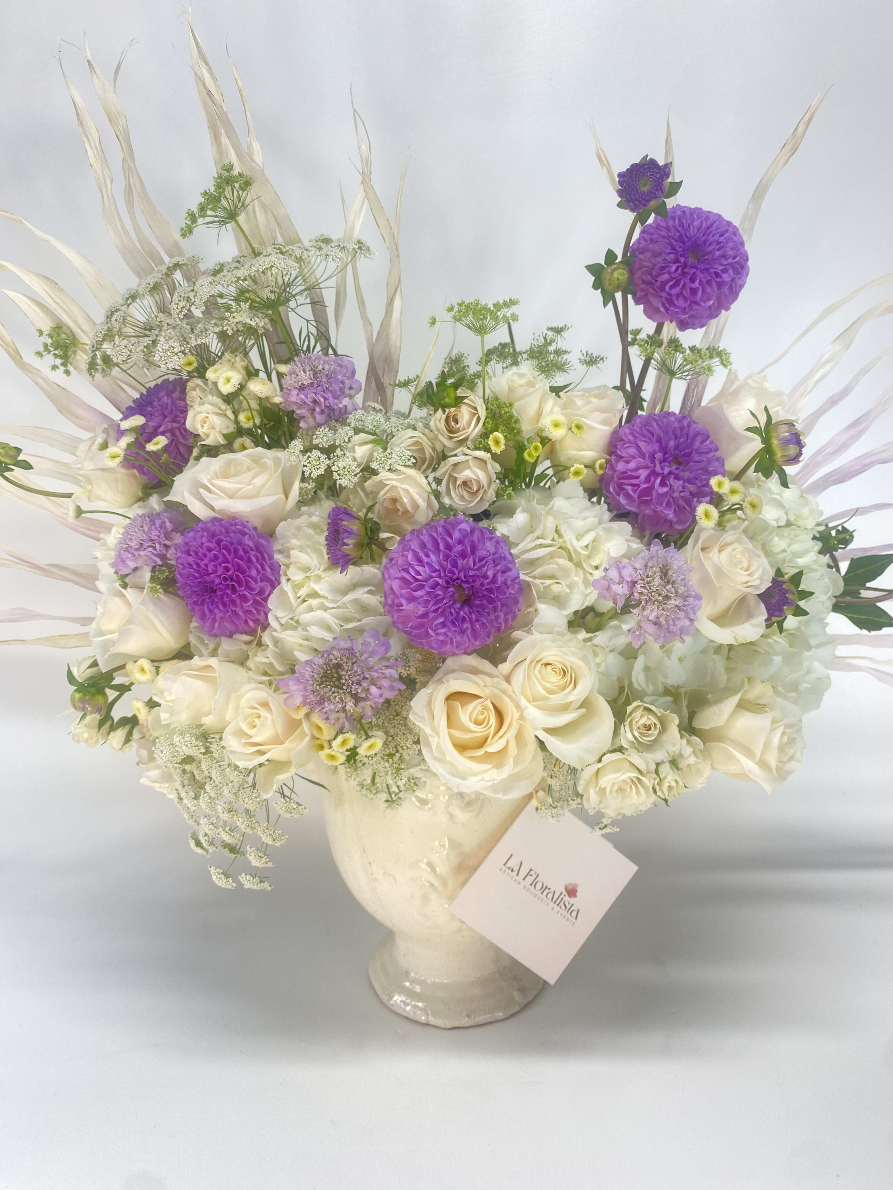 Cream and purple floral arrangement in a glass vase