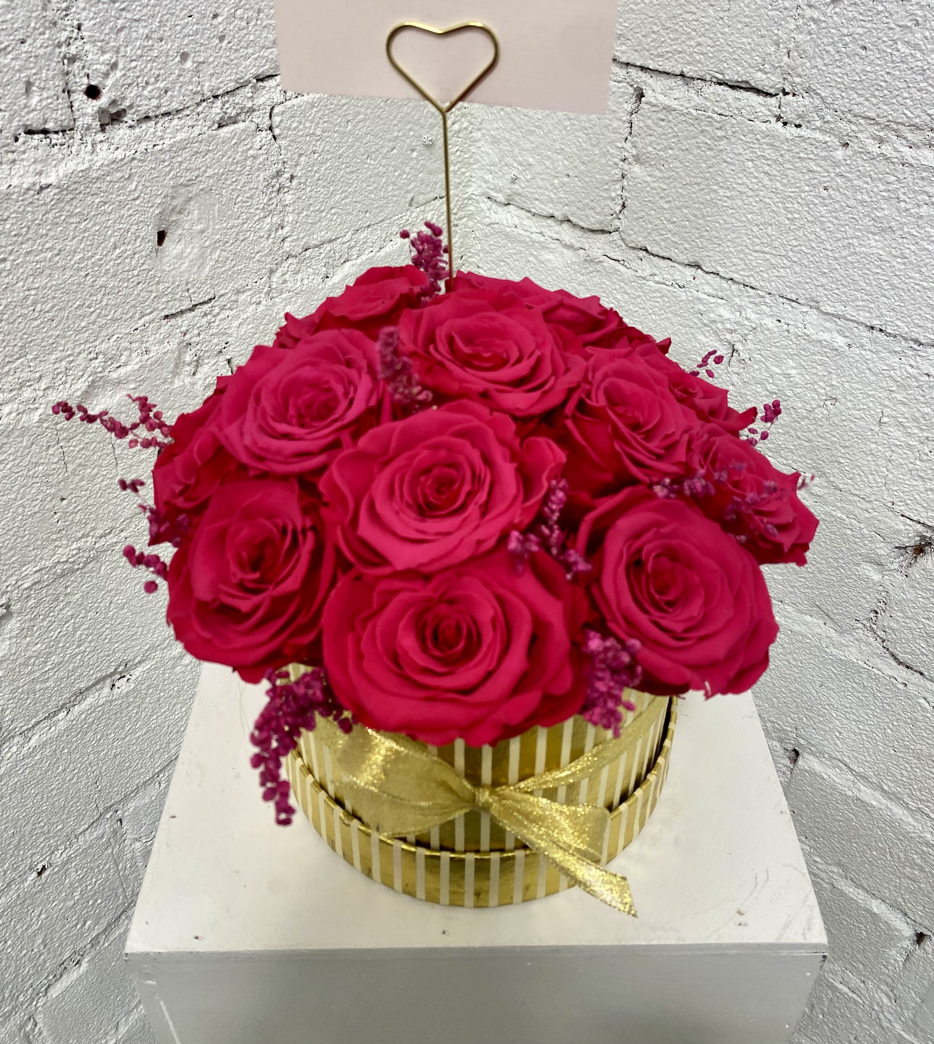 Hot pink roses in a gold striped box with a heart pick