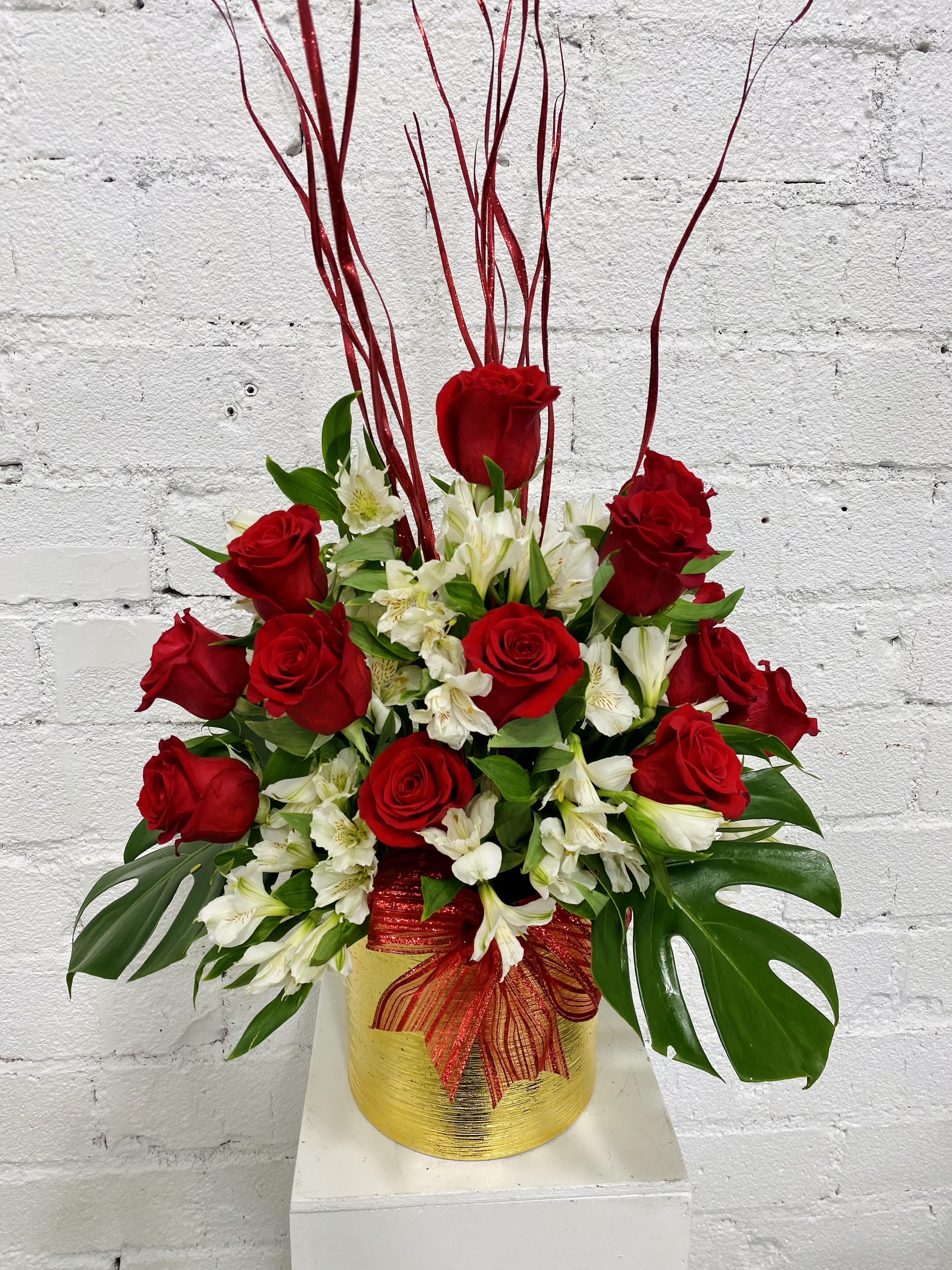 Synergy of Love - Valentine’s Day 2024! Stunning tall flower arrangement of 16 red roses, White alstroemerias and mini monstera leaves.