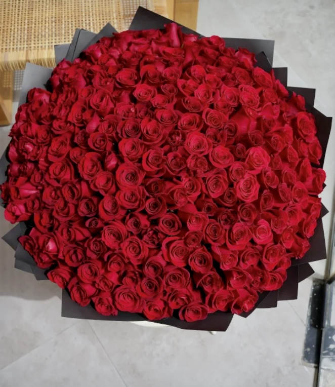 Large bouquet of red roses wrapped in black paper