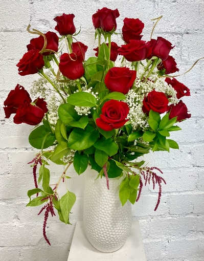 Red roses arranged in a white textured vase