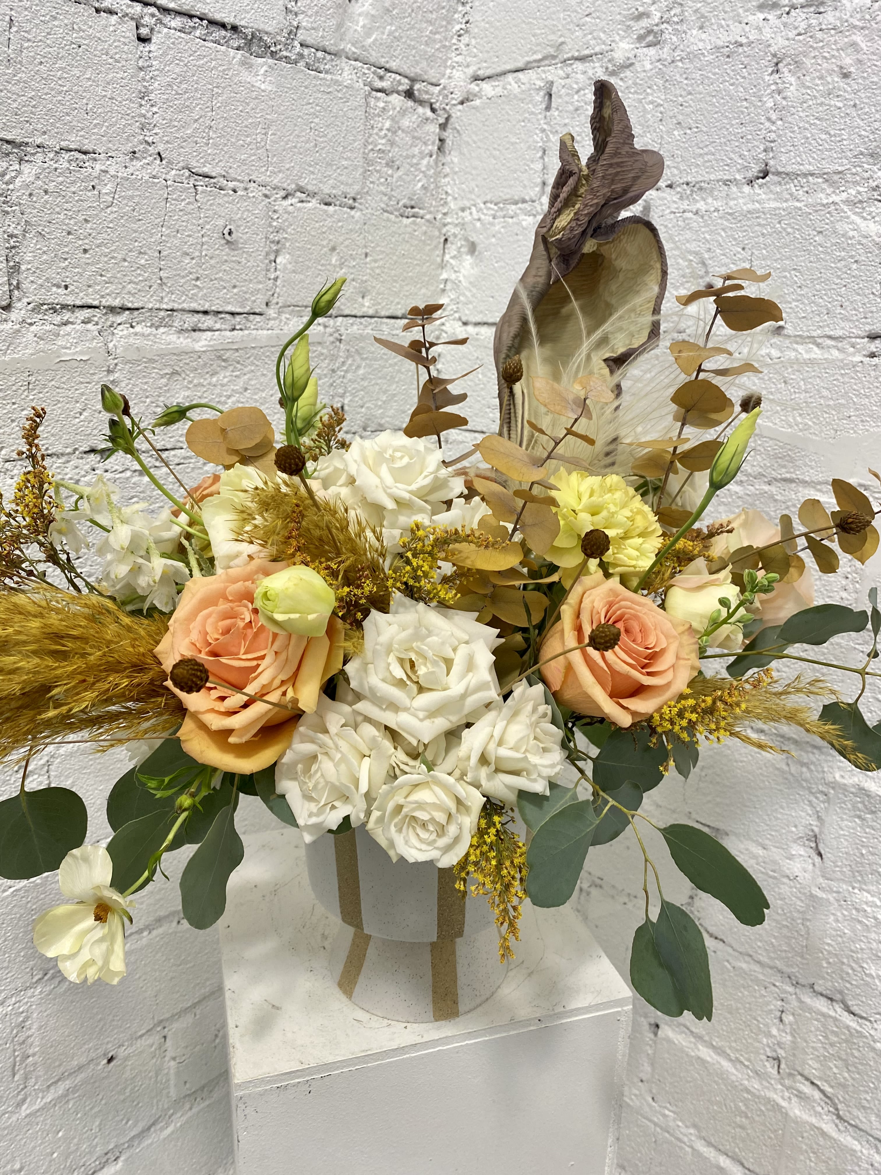 Peach and white rose arrangement in a white hatbox with dried accents