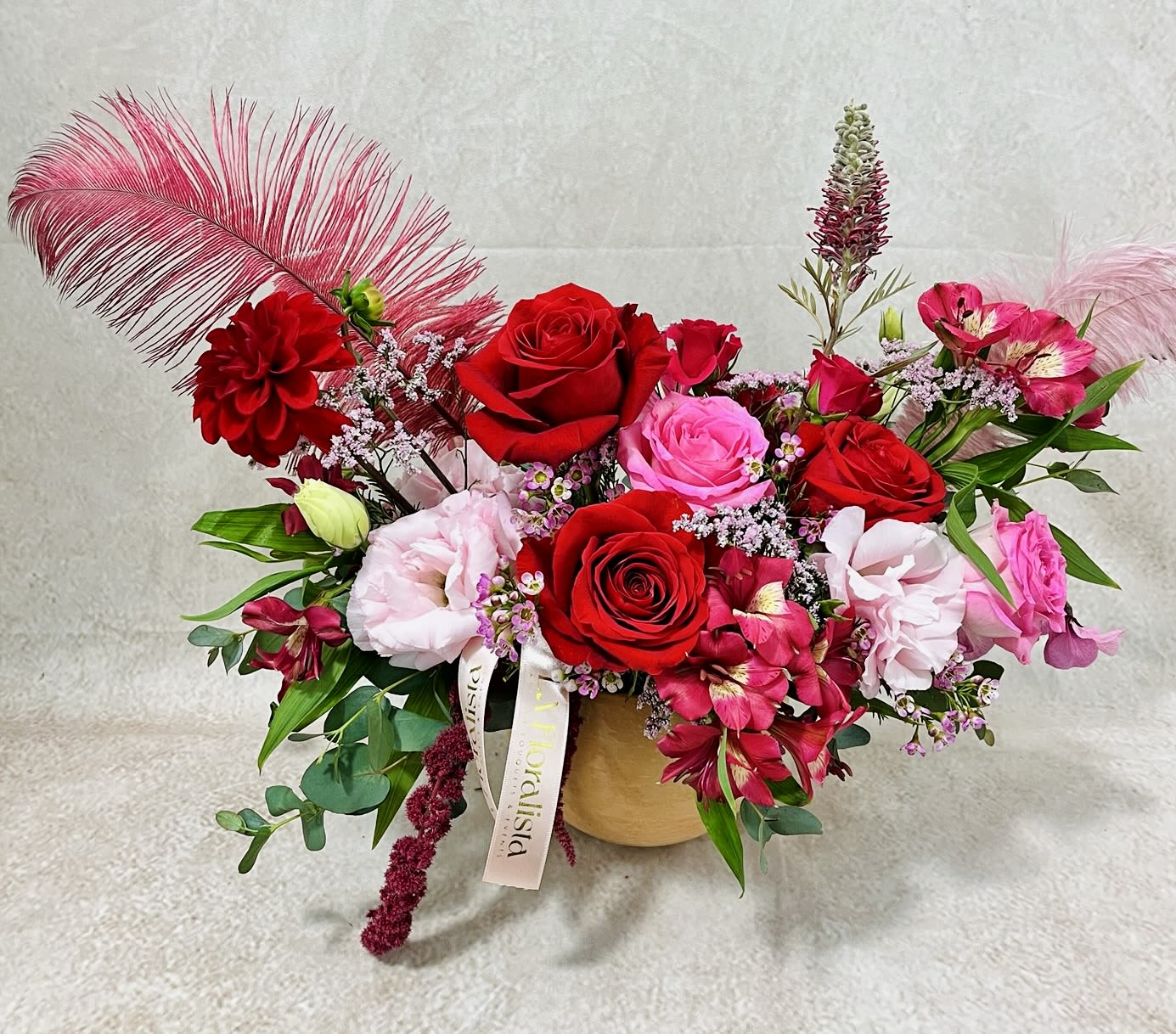 Mixed bouquet of red and pink roses in a gold vase