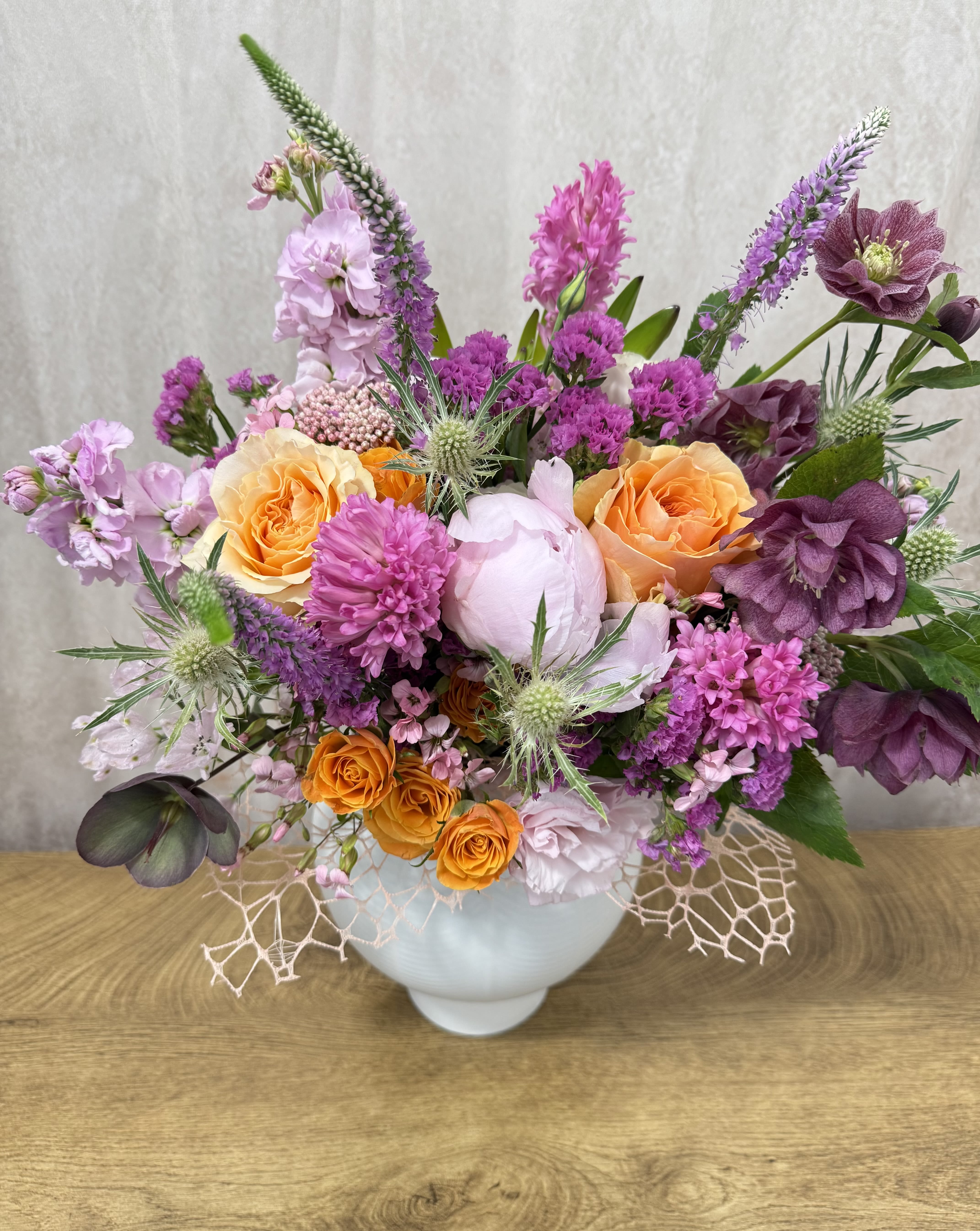 Mixed bouquet in a white vase with orange and purple flowers