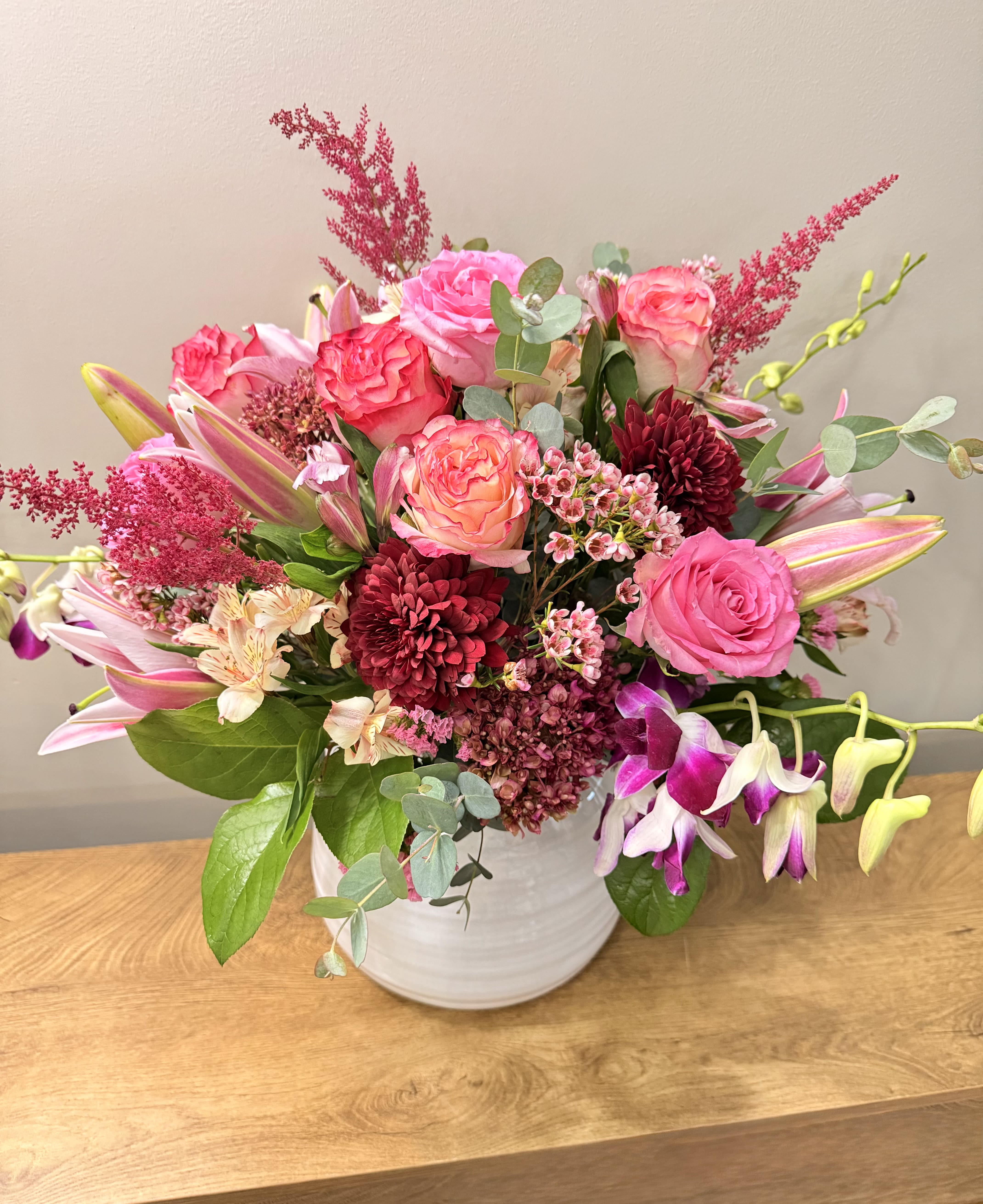Pink and burgundy mixed bouquet in a white vase