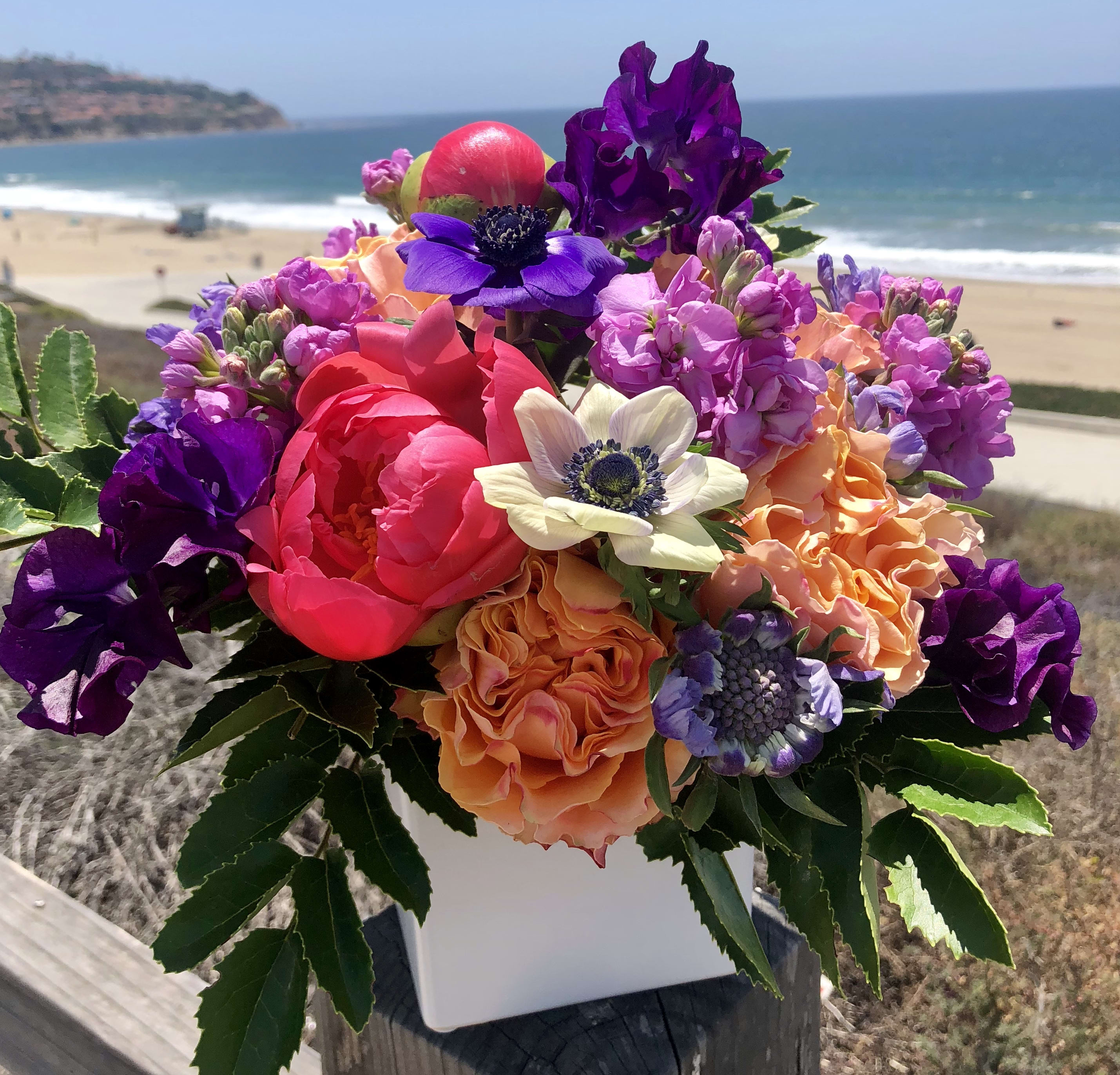 Colorful bouquet of mixed flowers in a white container
