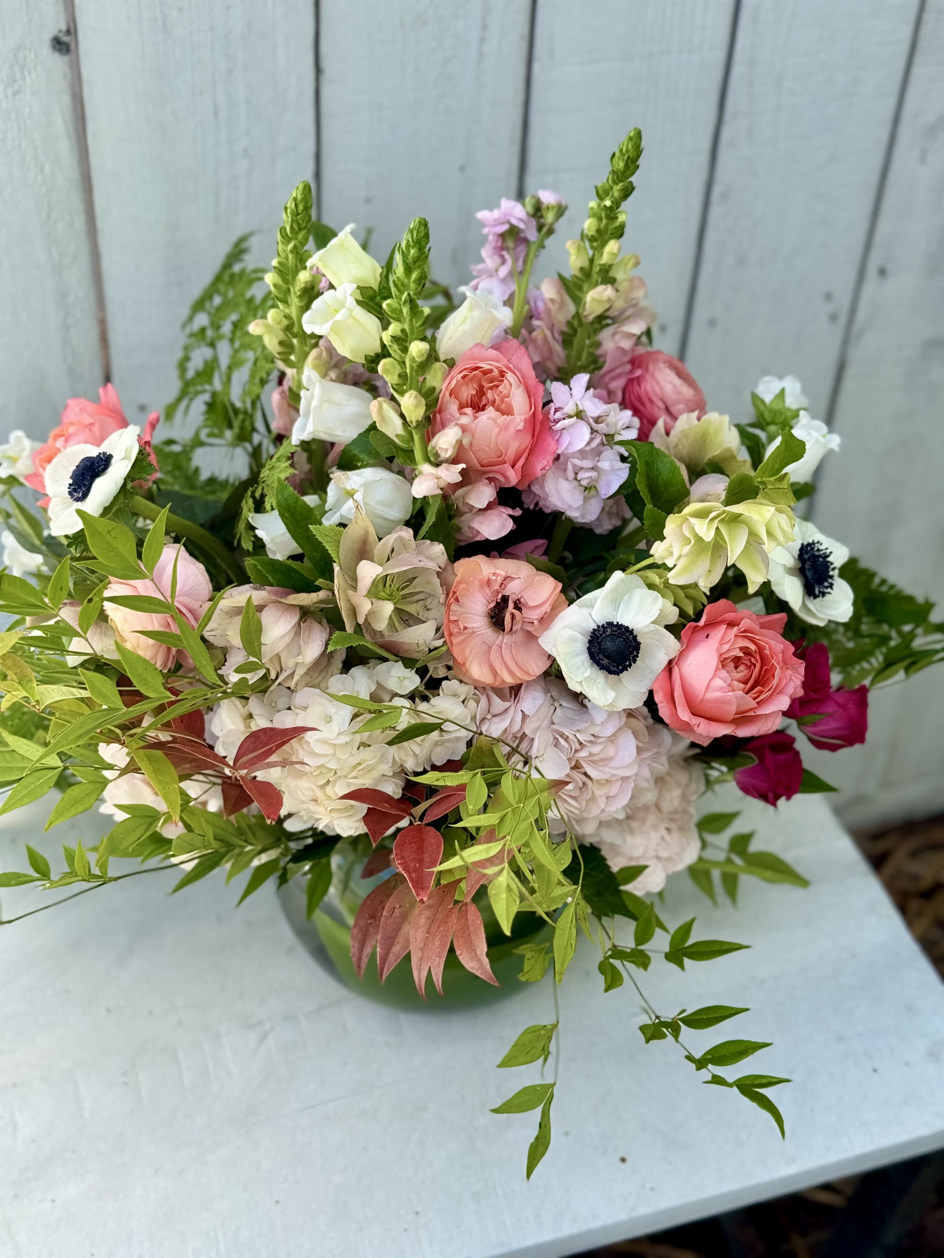 Mixed pink and white bouquet with anemones and roses in a vase