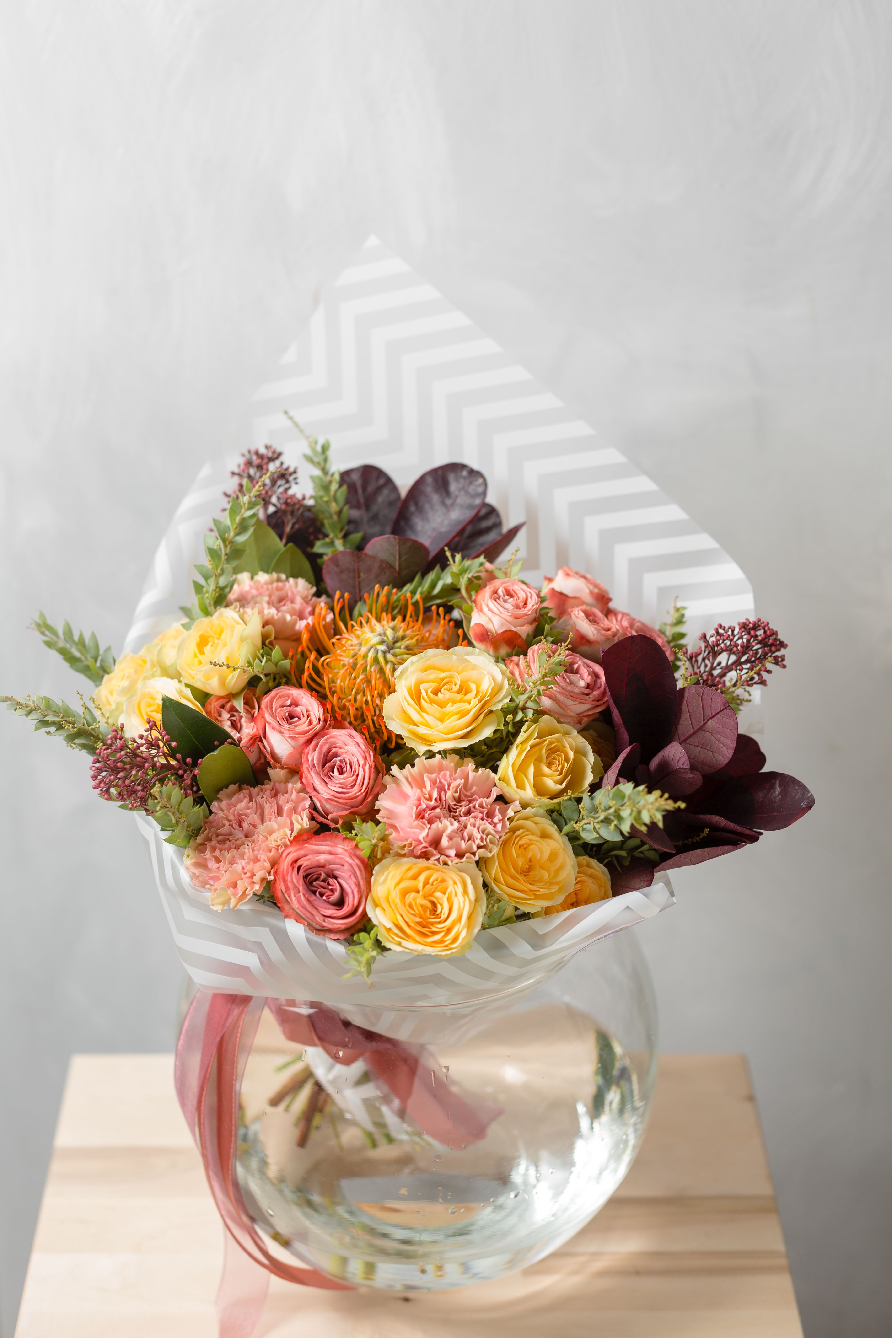 Spring Sunrise Bouquet  - Brighten any day with our Spring Sunrise Bouquet , a handcrafted arrangement featuring peach roses, cheerful daffodils, soft ranunculus, spray roses, and seasonal greenery.Wrapped in soft neutral tones and finished with a satin bow, its perfect gift for birthdays, anniversaries, or just because.