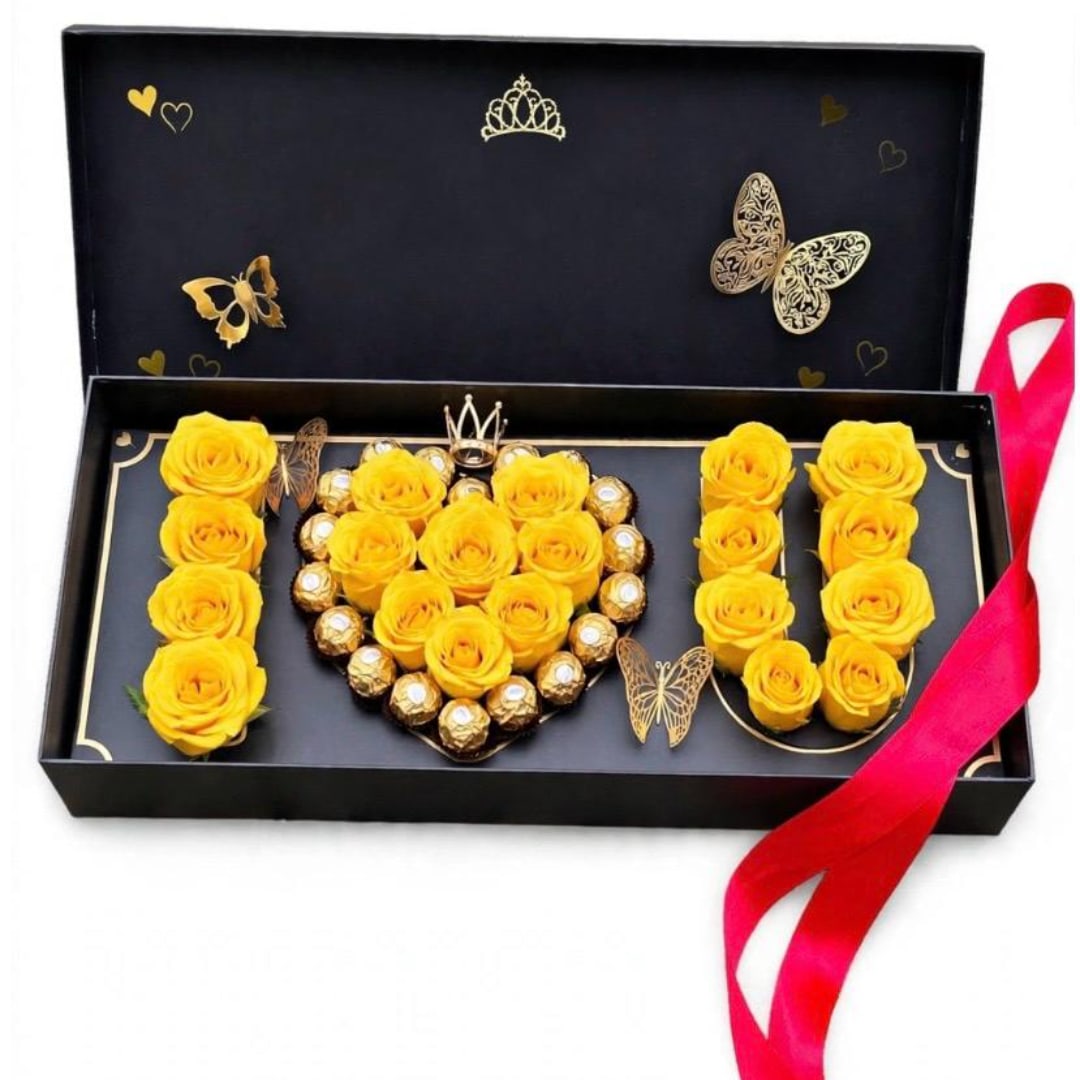 Yellow roses and chocolates arranged in a gift box with a pink ribbon