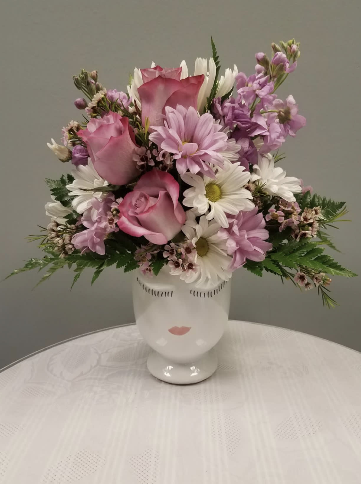 Pink and white mixed bouquet in a white face vase