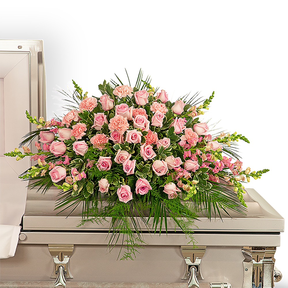 Forever Adored Casket Spray - Pink carnations symbolize thoughts of remembrance, while pink roses are a sign of appreciation and grace. We bring together these beautiful pink flowers in a stunning design we call our Forever Adored Casket Spray. It features delicate pink roses, carnations, snapdragons, Emerald, Plumosa, and premium foliage. The casket spray is typically provided by the spouse or immediate family as a heartfelt memorial from the family and is designed to sit on the lid of the casket for a funeral service or memorial.