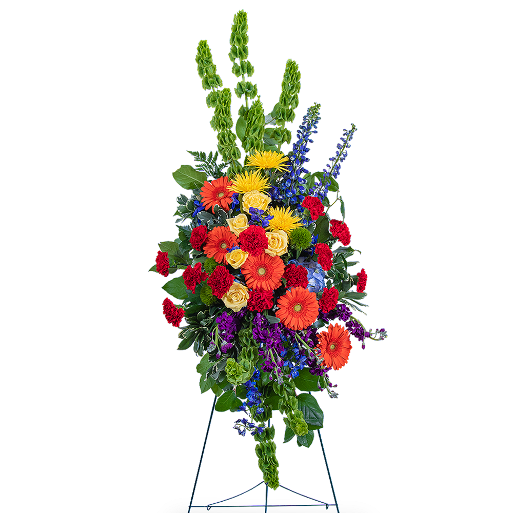 Tall standing floral spray with bright mixed flowers on a metal easel