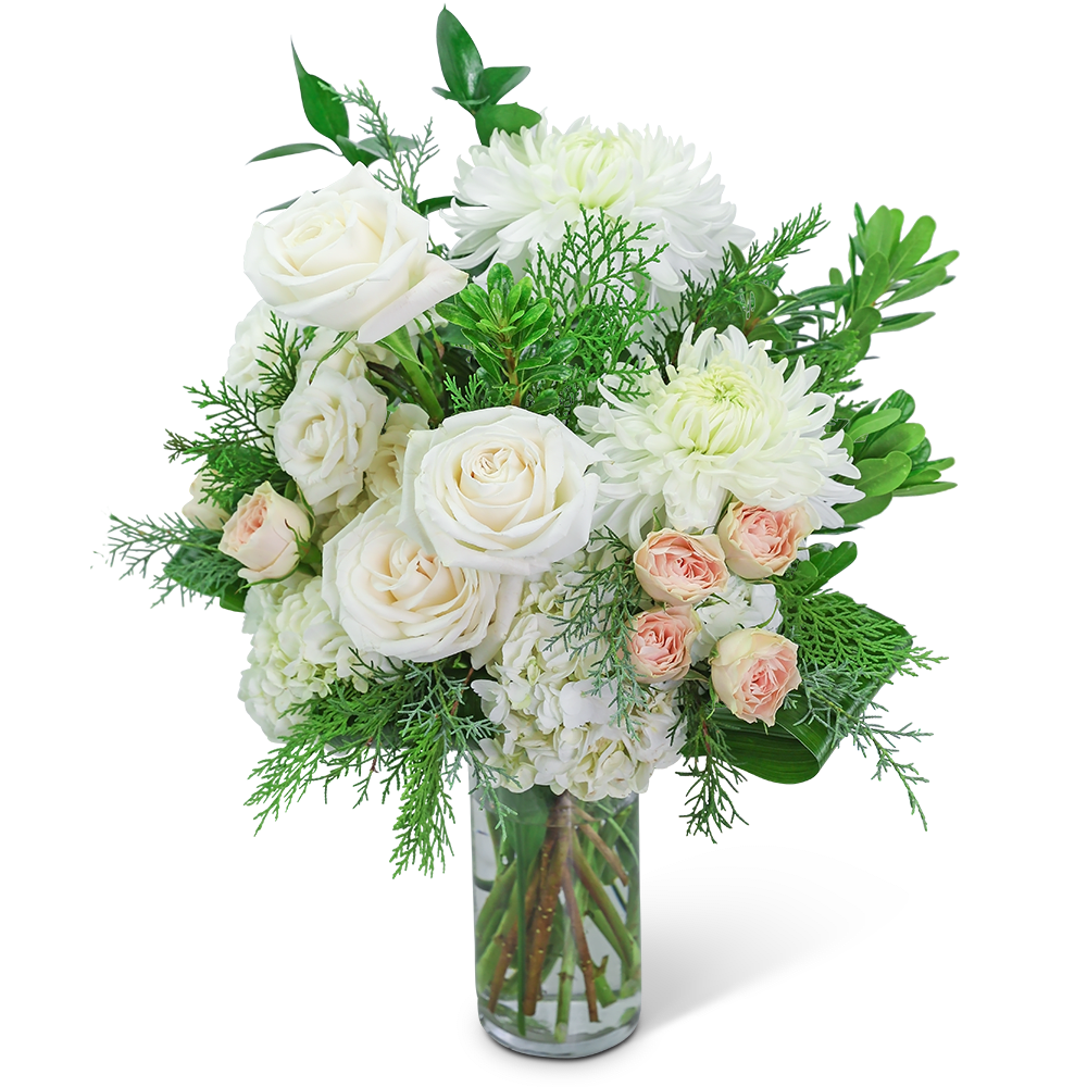 White roses and chrysanthemums in a clear glass vase with greenery