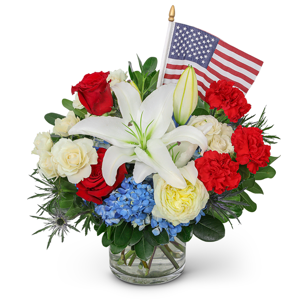 Red, white, and blue floral arrangement with an American flag in a glass vase