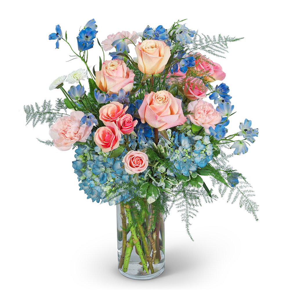 Pink roses and blue flowers arranged in a clear glass vase