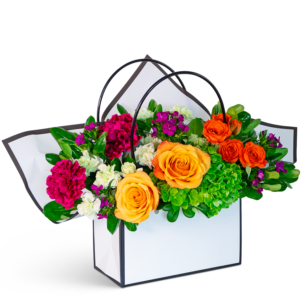 Bright mixed flower arrangement in a white handled gift box