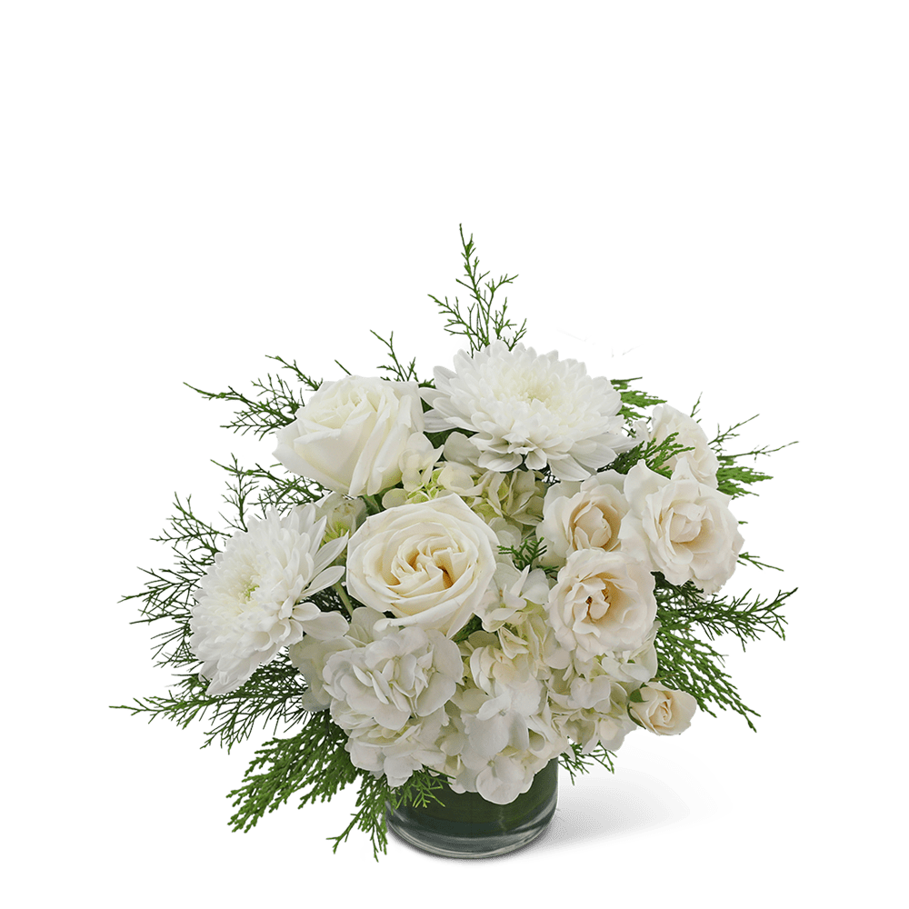 White roses and chrysanthemums in a glass vase with greenery
