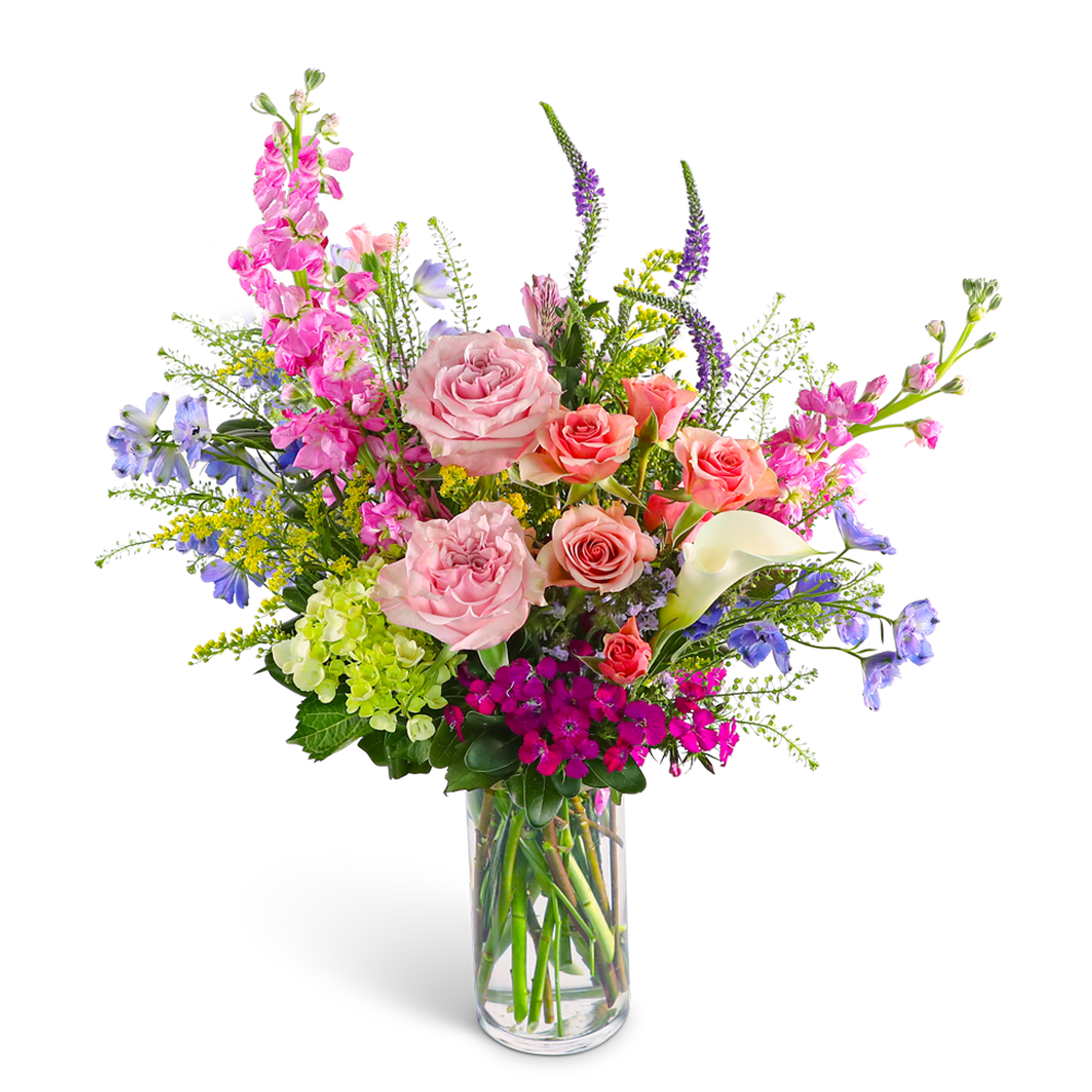 Mixed bouquet of pink roses, calla lily, and purple flowers in a glass vase