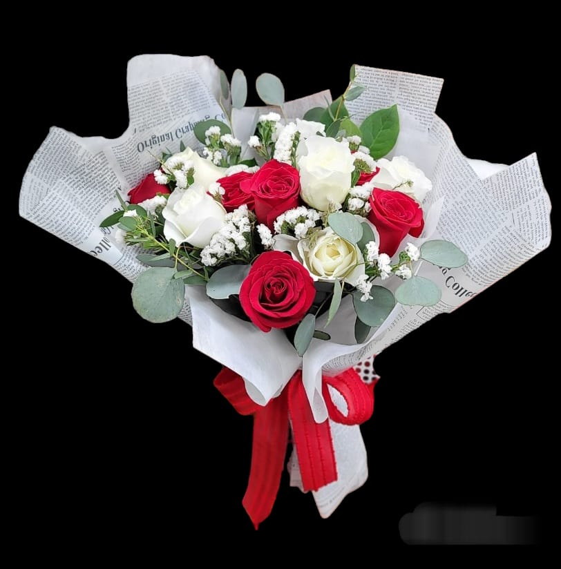 Bouquet of red and white roses wrapped in newspaper-style paper