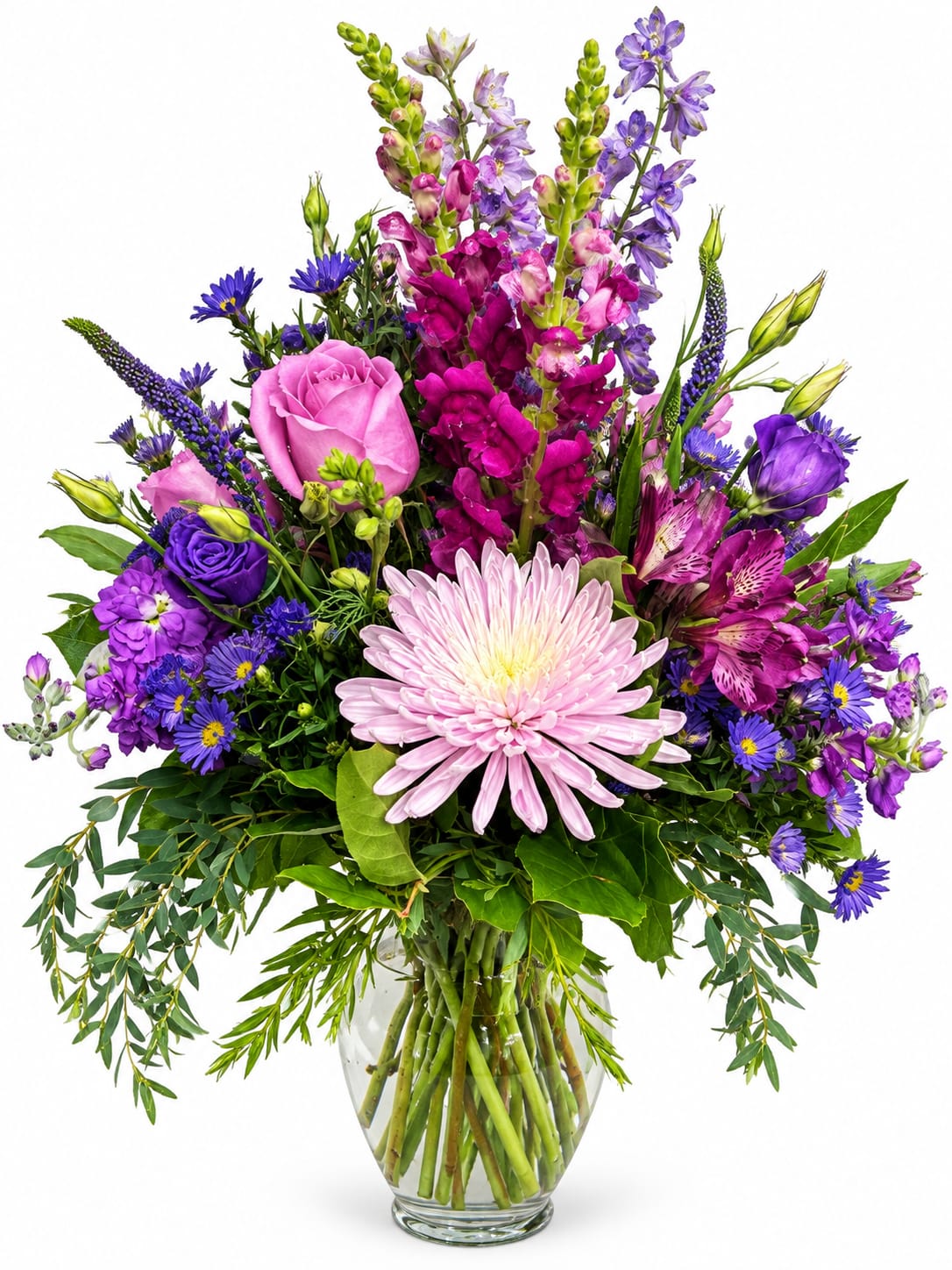 Mixed bouquet of pink, purple, and blue flowers in a clear glass vase
